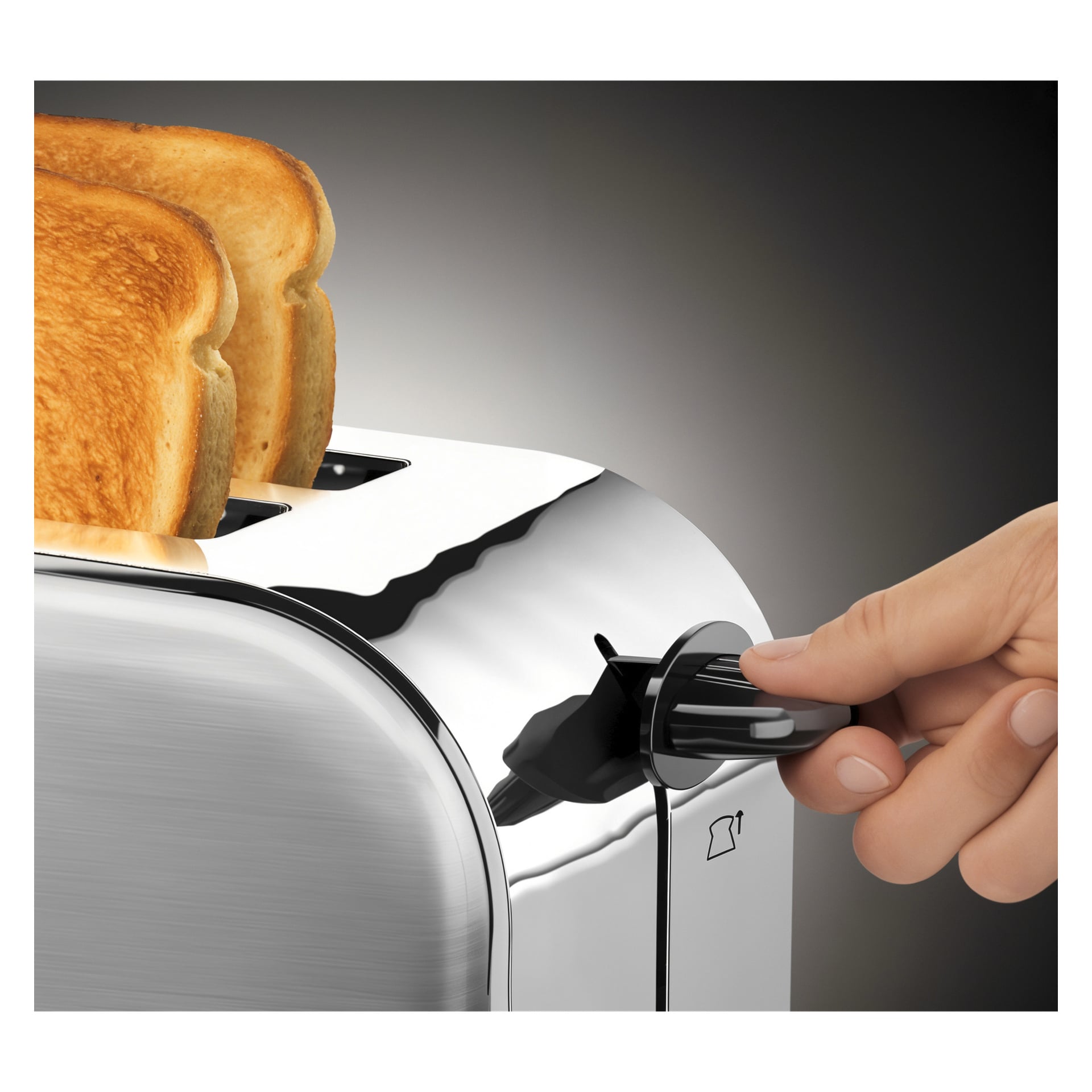 En hånd vrir på skiven på en Russell Hobbs Adventure 4-skives brødrister med to skiver toast inni, mot en mørk bakgrunn.