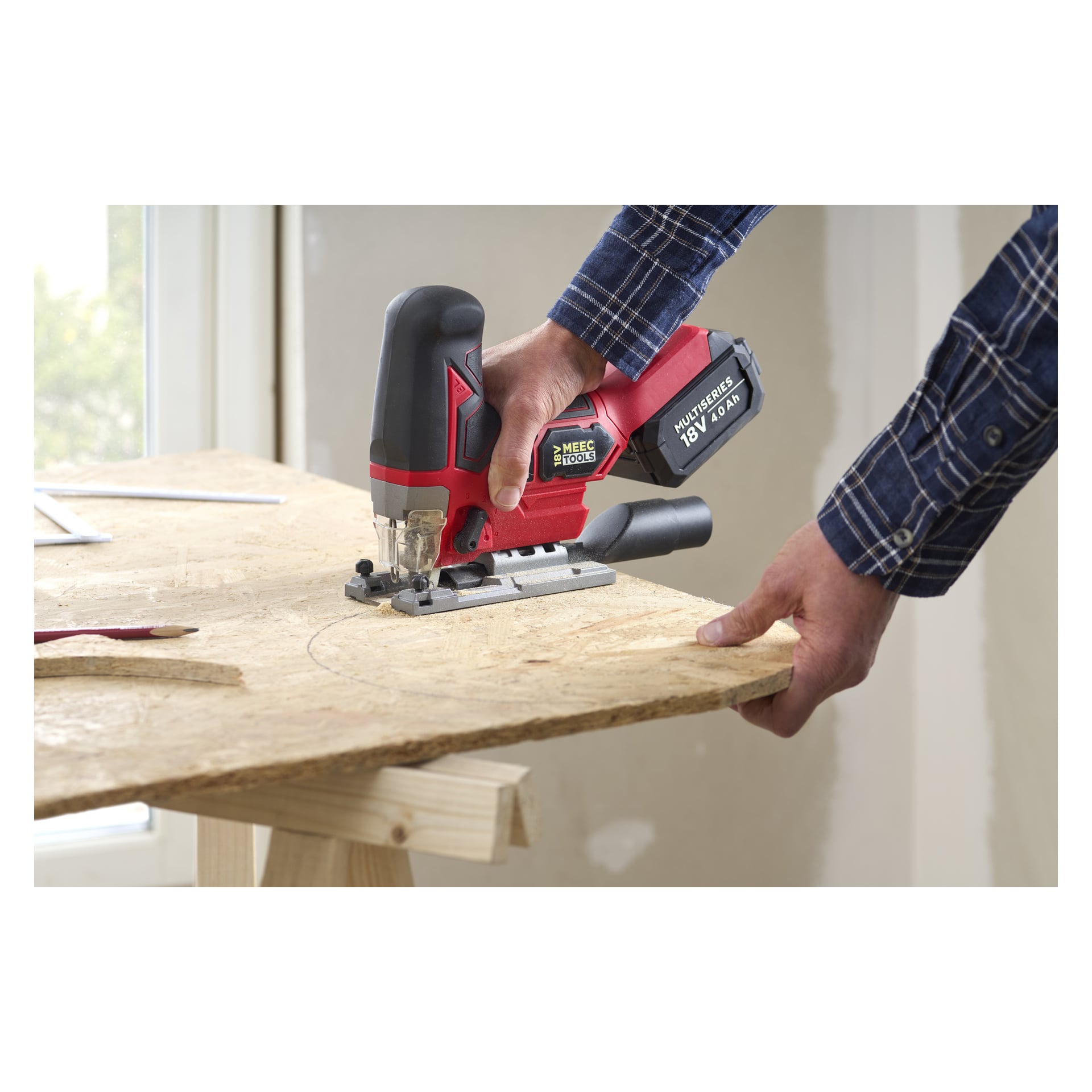 En person i en blå rutig skjorta använder en röd och svart Meec Tools-sticksåg för att såga en böjd linje i plywood på en träsåg.