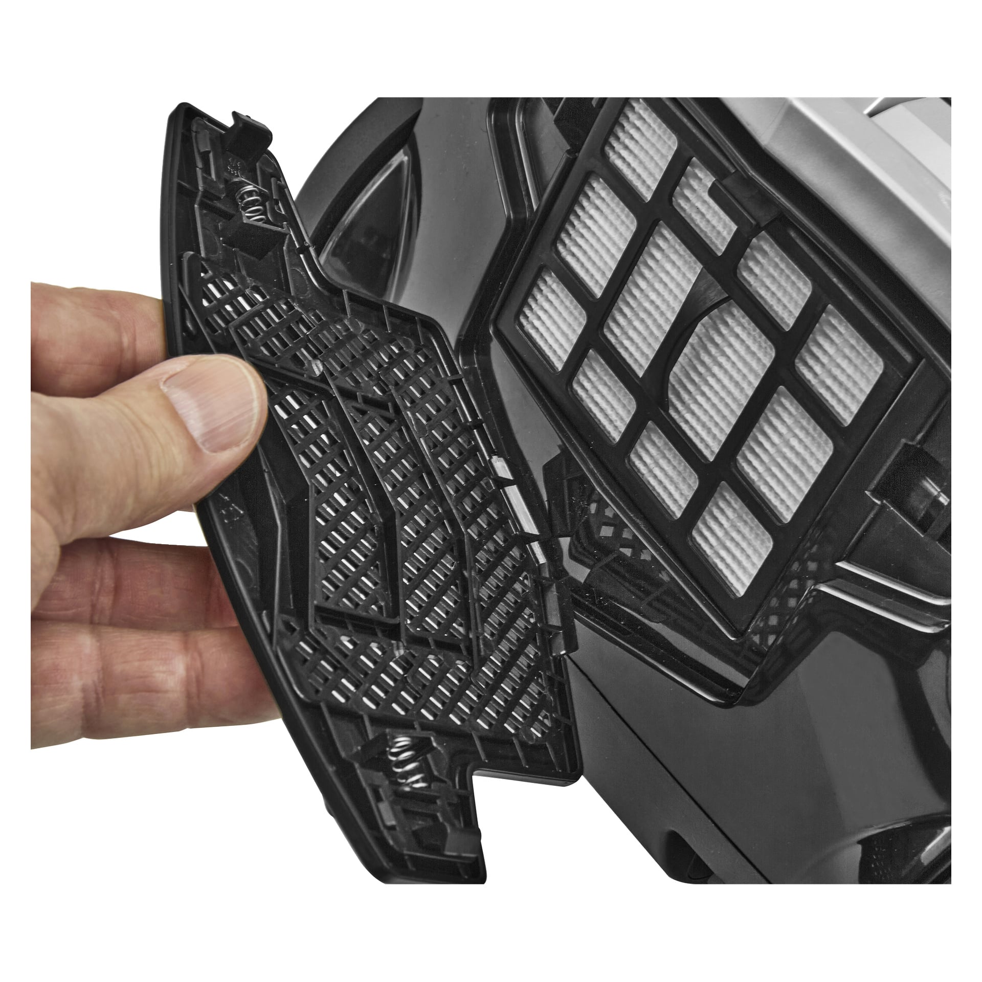 En hand lyfter plastlocket från Bright Vacpers filterspår och blottar ett vitt rektangulärt filter inuti dess svarta fodral.