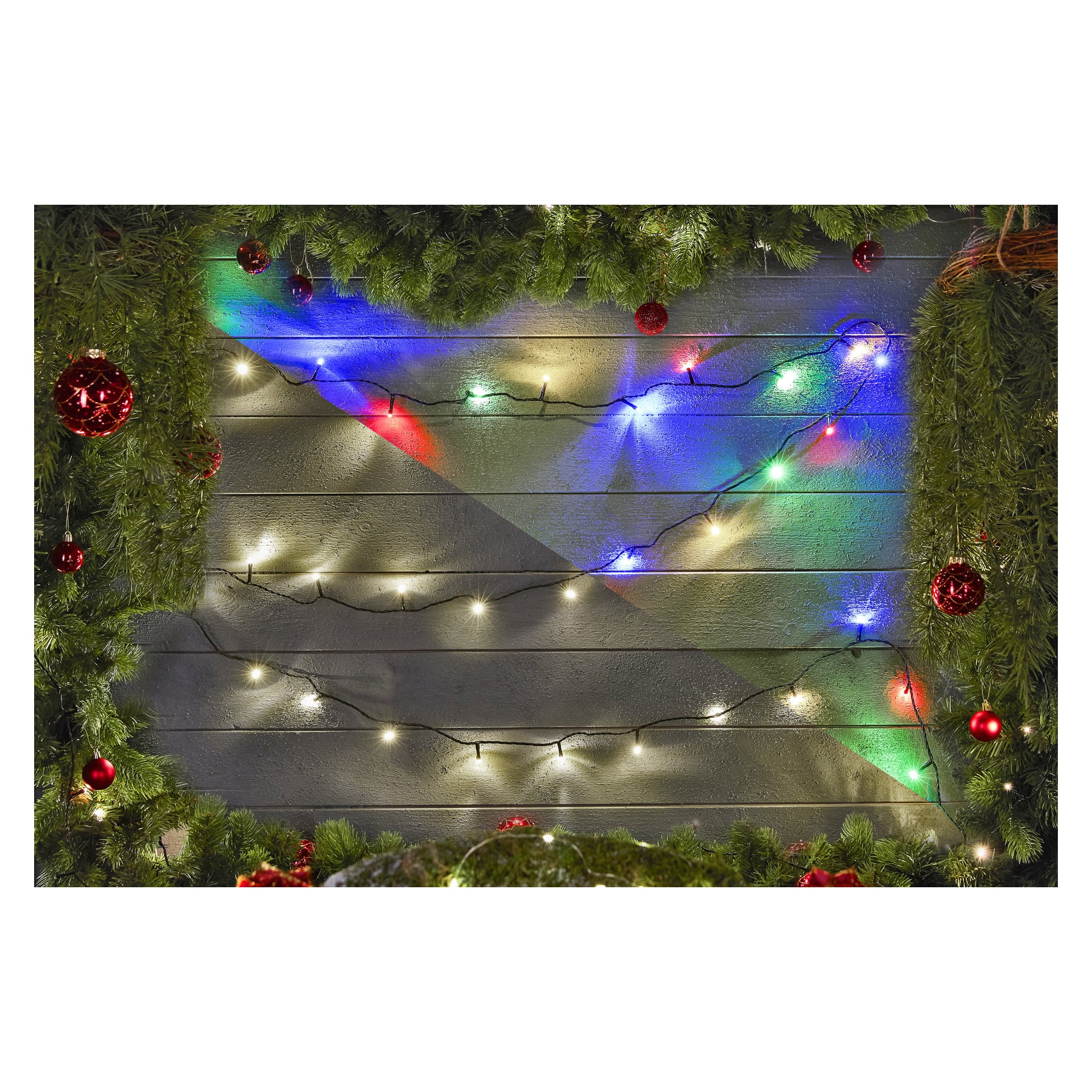 Gröna tallgirlander, röda prydnader och EKVIP LED-ljusslingor pryder en trävägg och framkallar en festlig julstämning.
