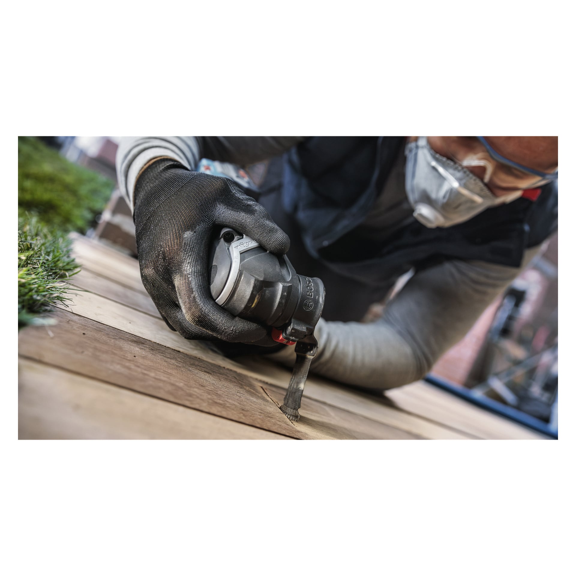 Noen, utstyrt med sikkerhetsutstyr, bruker et Bosch Pro Saw-blad AIZ32BSPIB (5-pakning) for å kutte trebord utendørs.