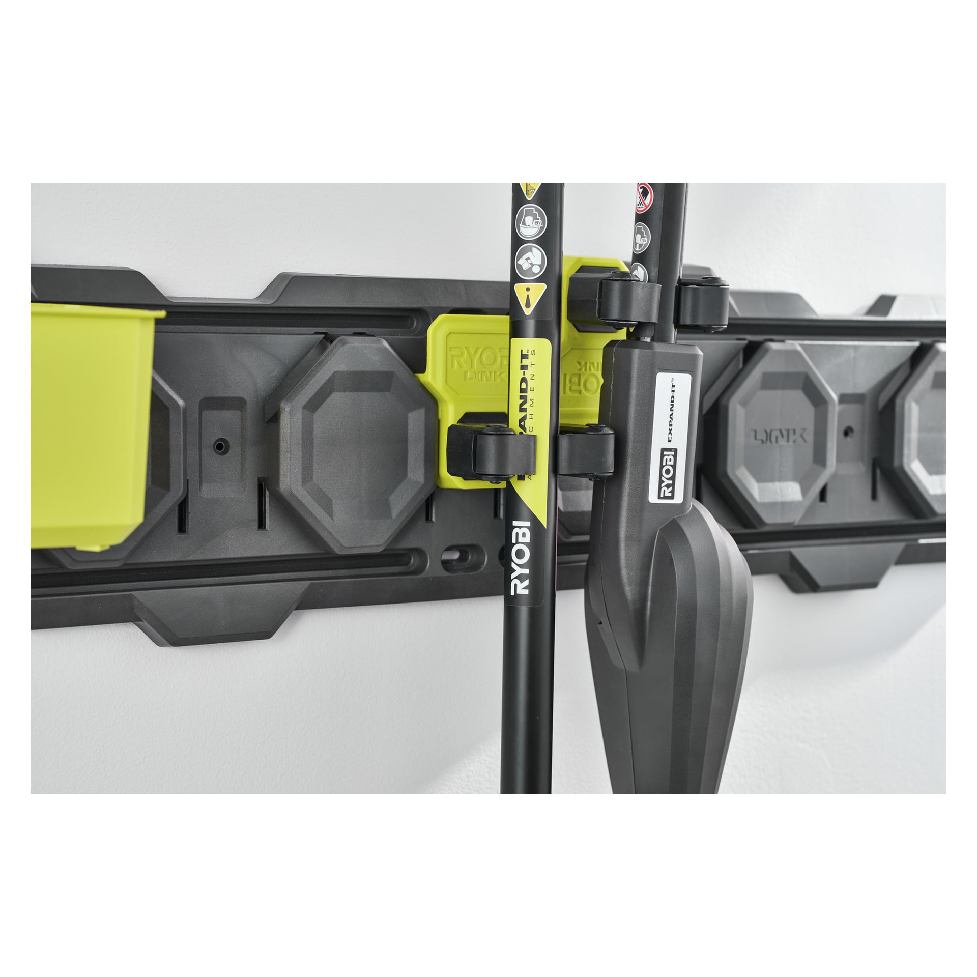 Ett Ryobi Clamp-krok LINK RSLW824 väggförvaringssystem håller olika trädgårdsredskap snyggt med svarta och gröna fästen.