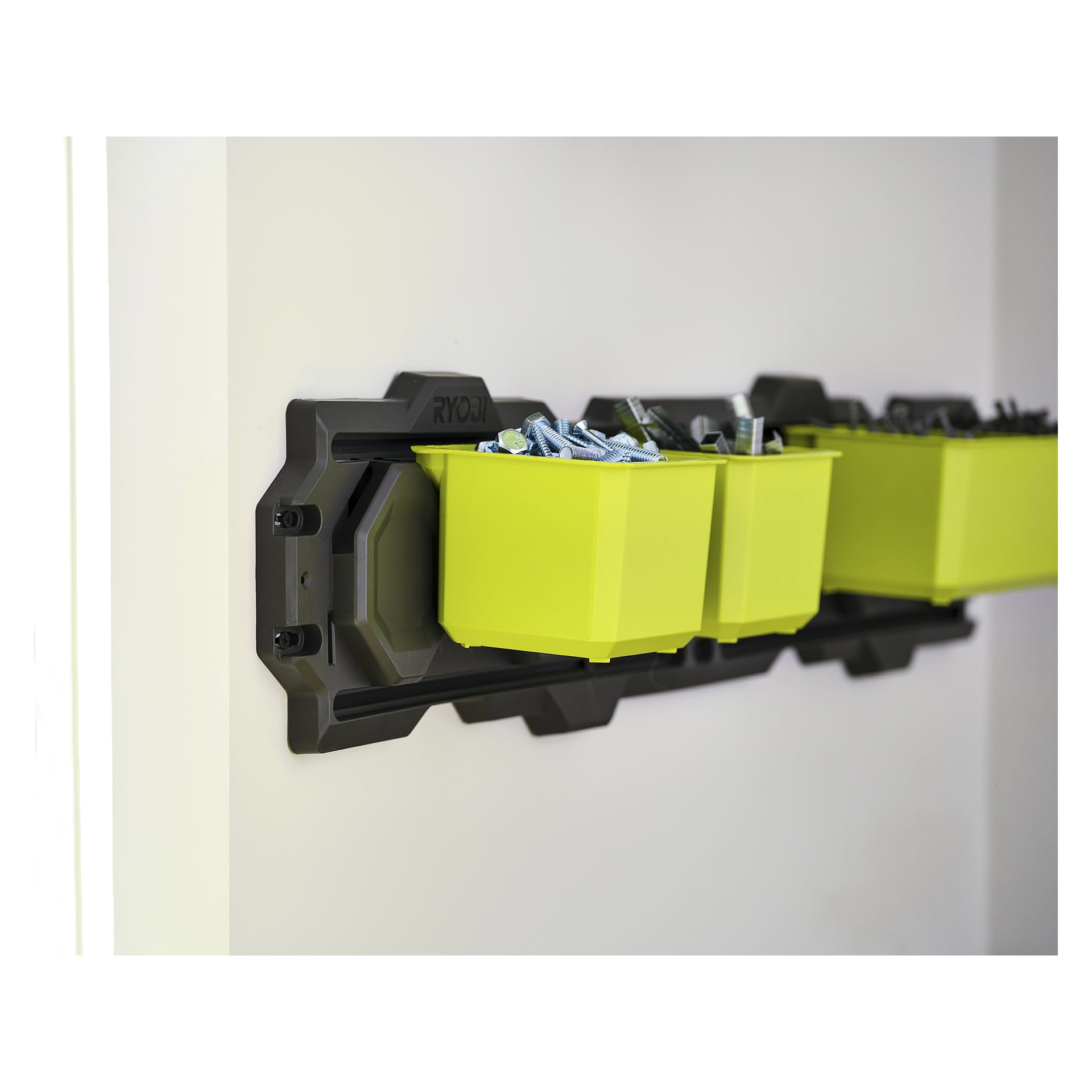 Närbild av Ryobi Storage Box S LINK RSL813 med två gula lådor som håller skruvar och fästen, monterade på en svart skena.