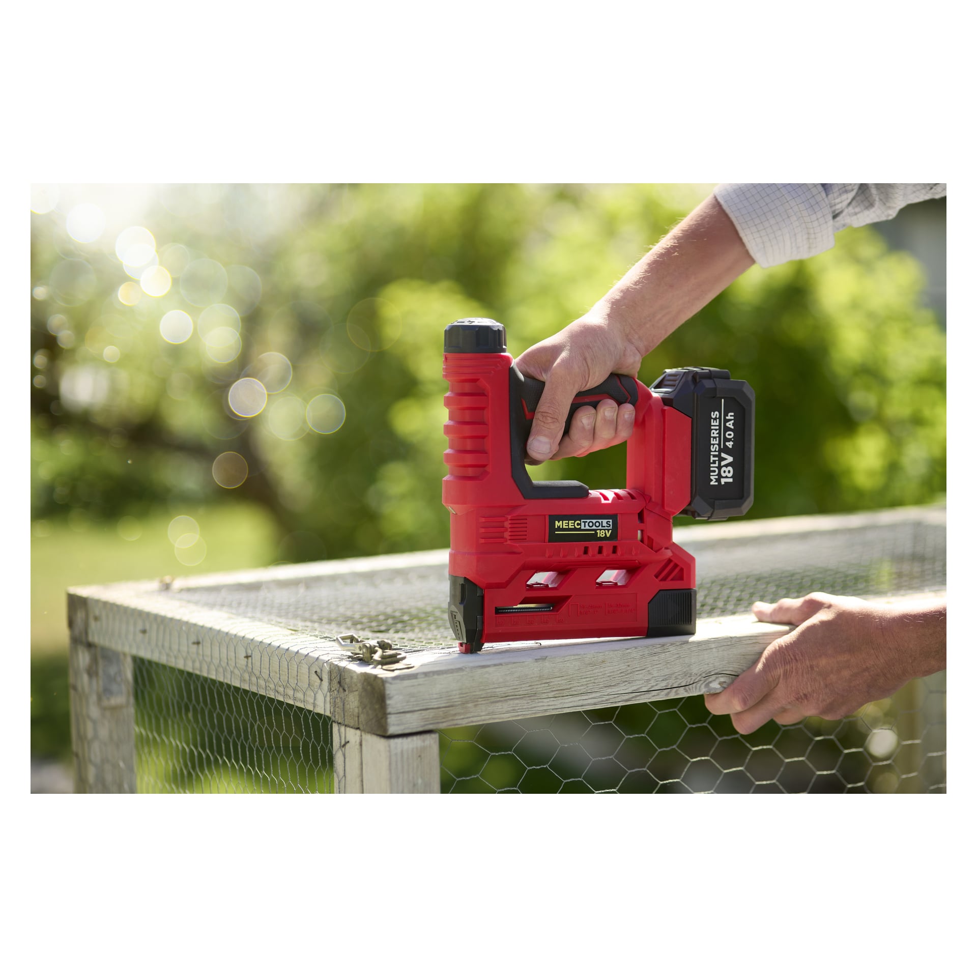 Någon fäster trådnät på en träram med hjälp av en Meec Tools Multiseries NG-18V HOME 300 sladdlös häftpistol.
