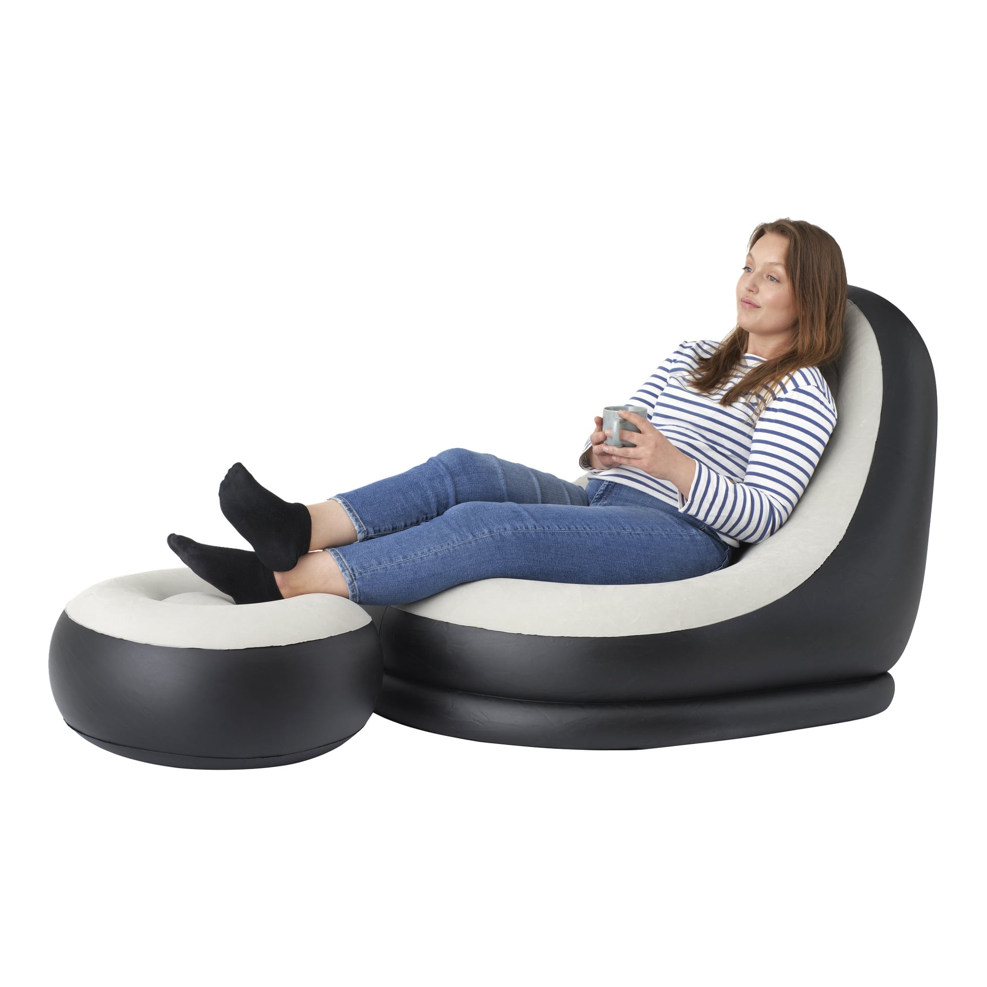En kvinne iført stripete skjorte og jeans slapper av med en kopp, sittende på Jilong Inflatable Lounger og matchende fotstol.