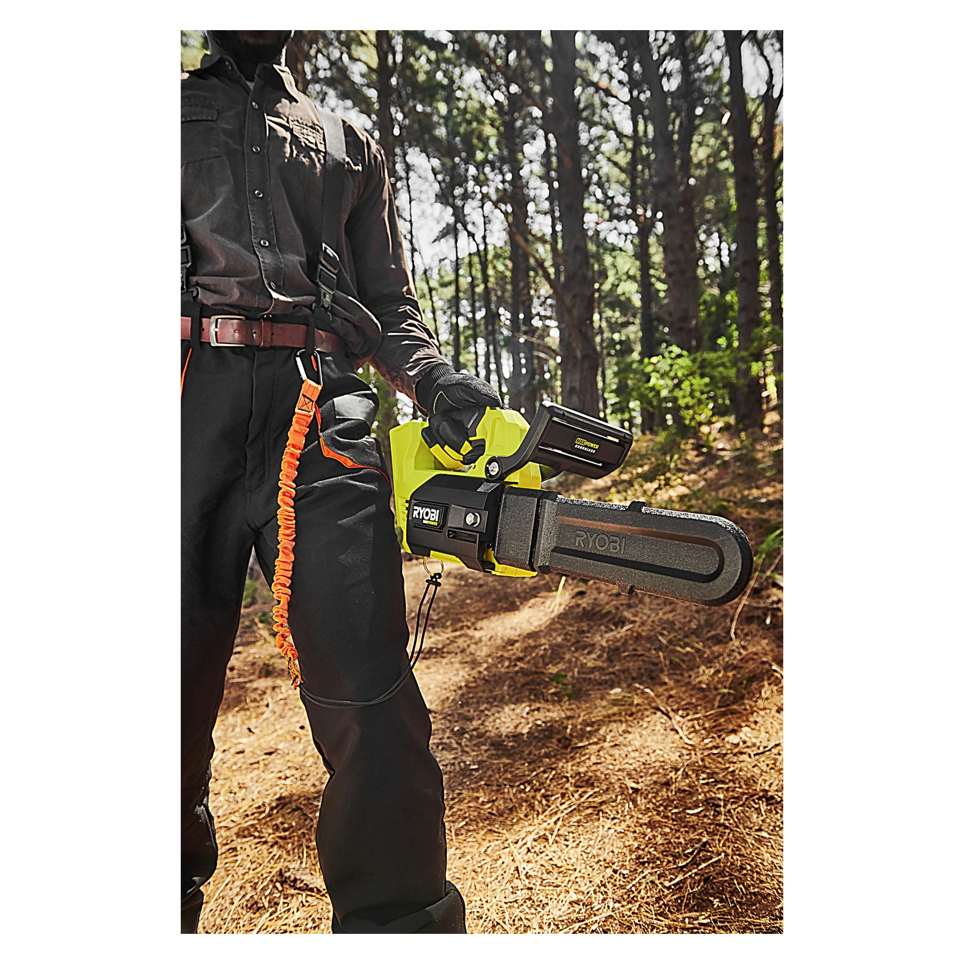 Med skyddsutrustning håller man en Ryobi Max Power-motorsåg i en ljus skog med träd och bruna tallbarr runt omkring.