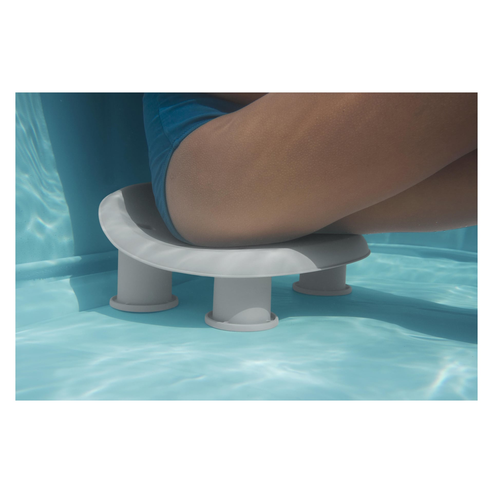 En person i blå badkläder sitter på en rund, vit Bestway LAY-Z-SPA stol med fyra ben, nedsänkt i en klar pool.