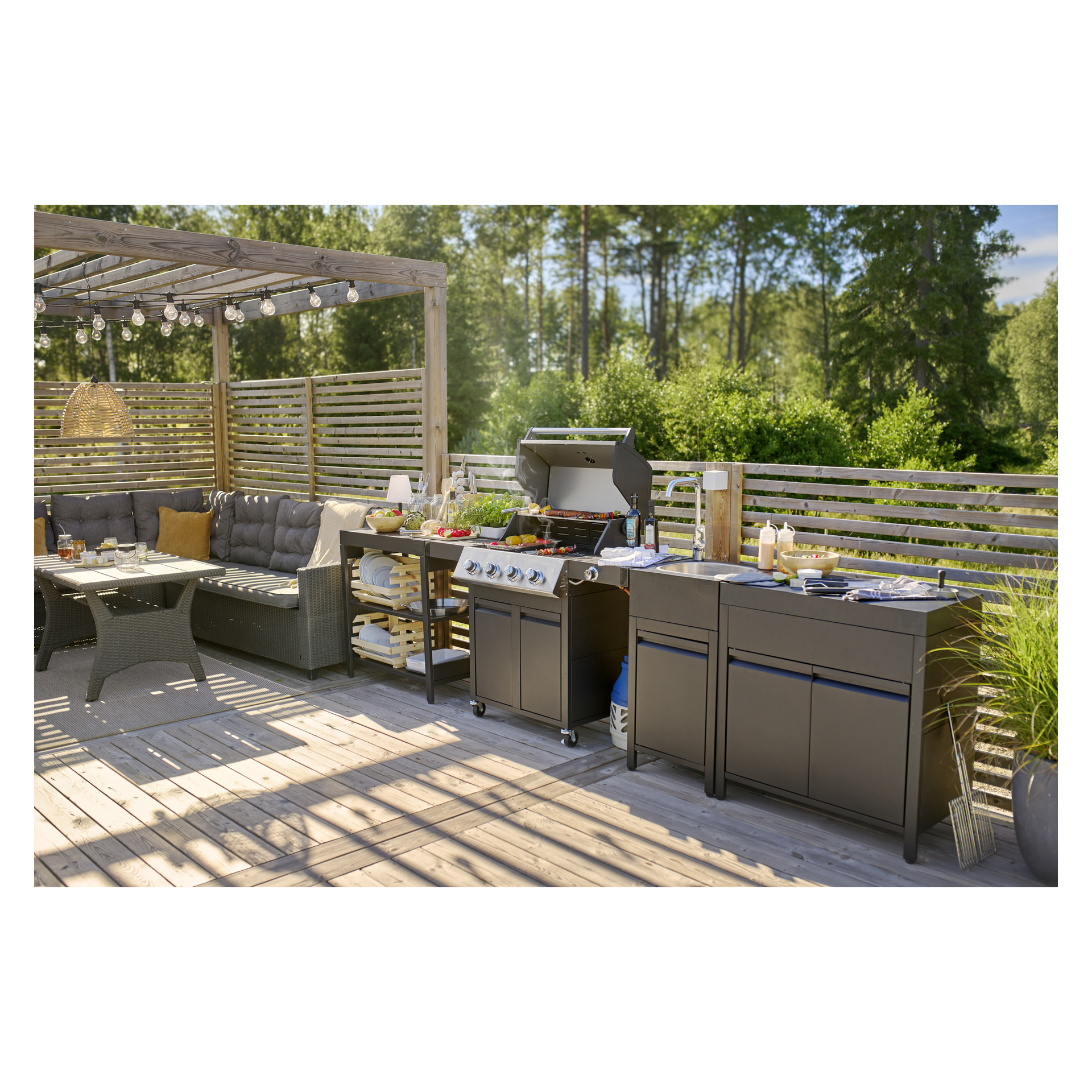 Korgkorg, vadderade sittplatser, matbord, grill med mat, ljusslingor, träpaneler, grönska och 8043B arbetsbänk.