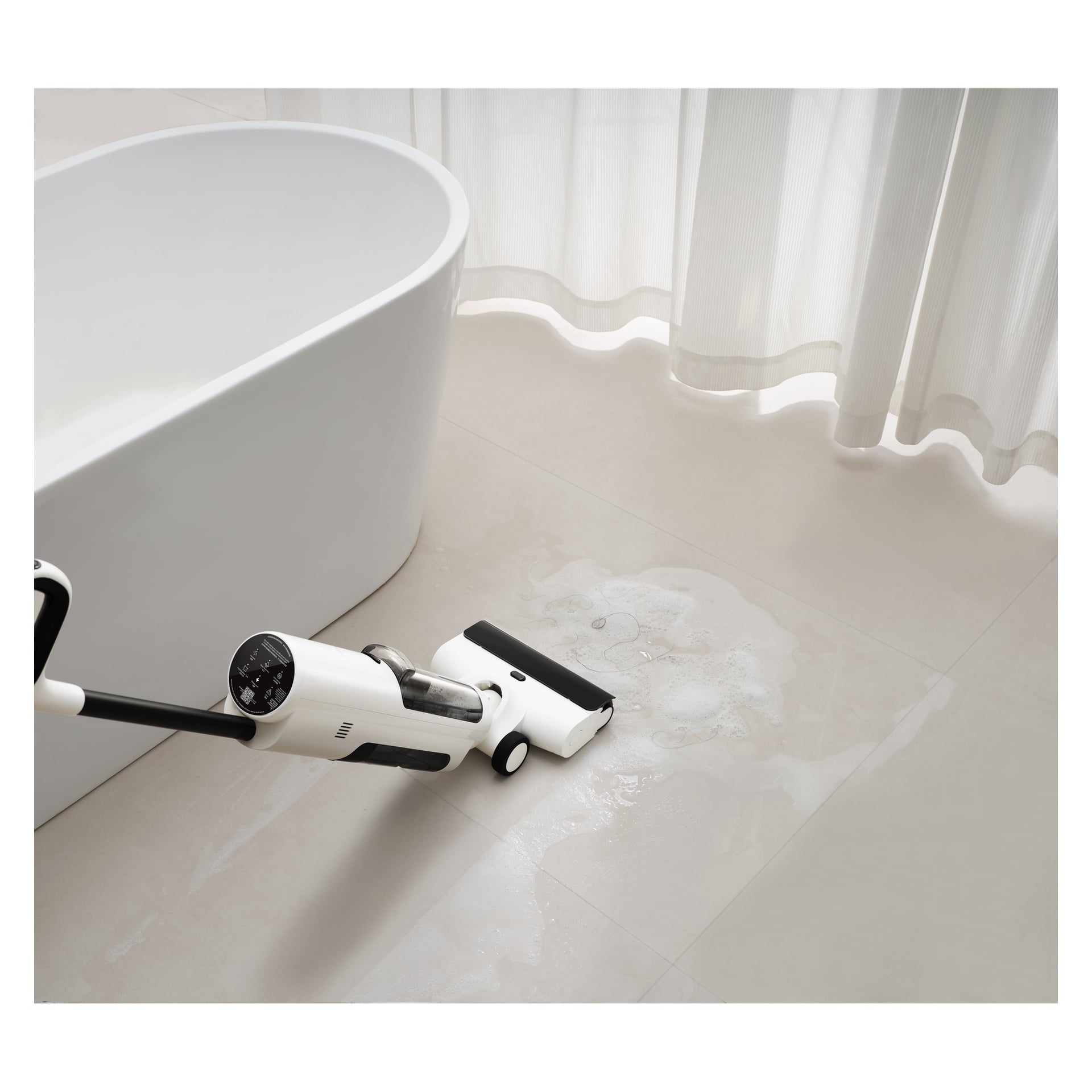 Ein Xiaomi Upright 3-in-1 Staubsauger mit Wischmopp, Truclean W20, entfernt einen feuchten Fleck auf einem hellen Badezimmerboden in der Nähe einer Badewanne und transparenten Vorhängen.