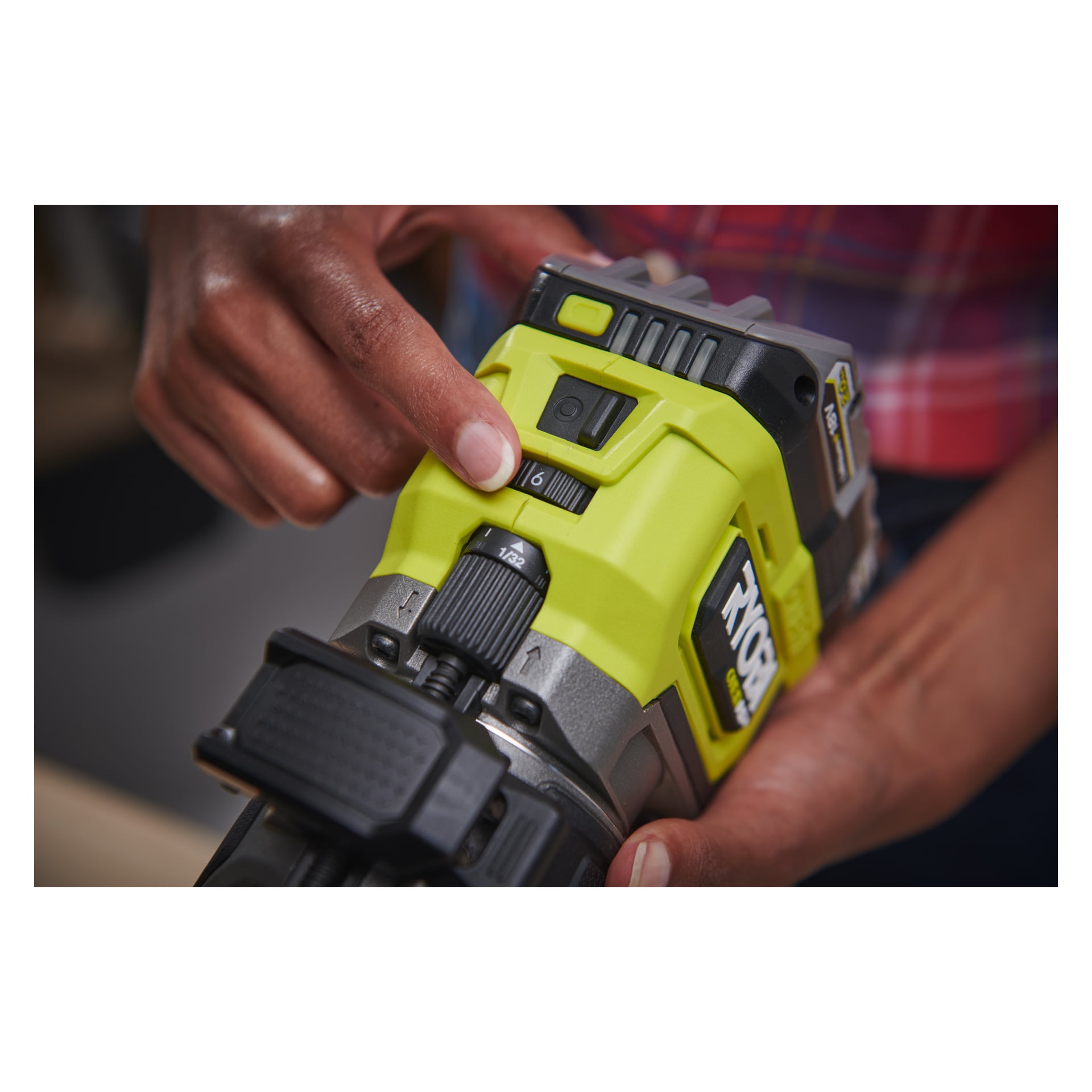 En person vrir hurtigvalget på en grønn Ryobi One+ HP-ruter RTR18C-0, som har en svart bryter og delvis merkevarelogo synlig.