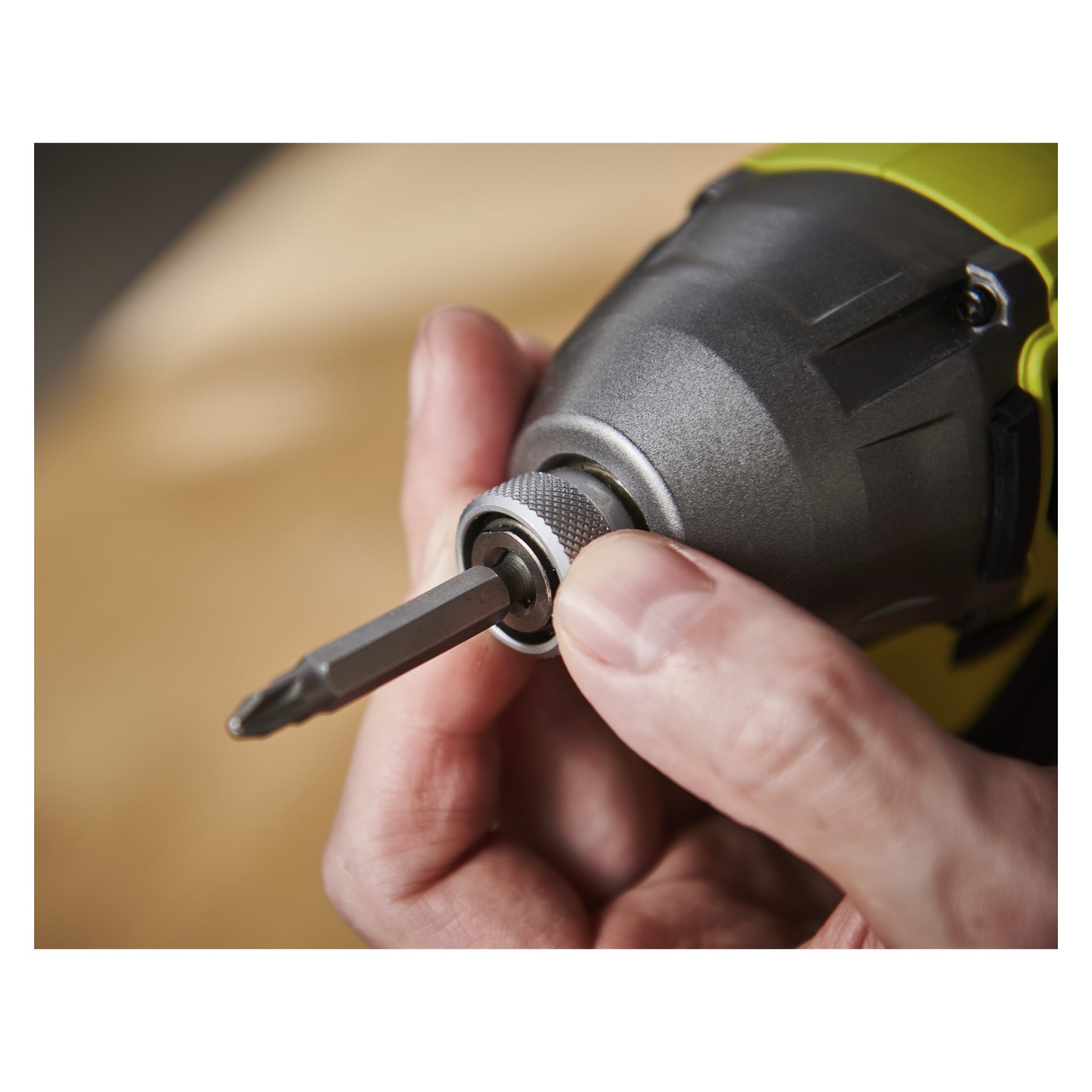 En persons hand passar en Phillips-bit i chucken på en Ryobi One+ HP Brushless slagdragare RID18X1-0.