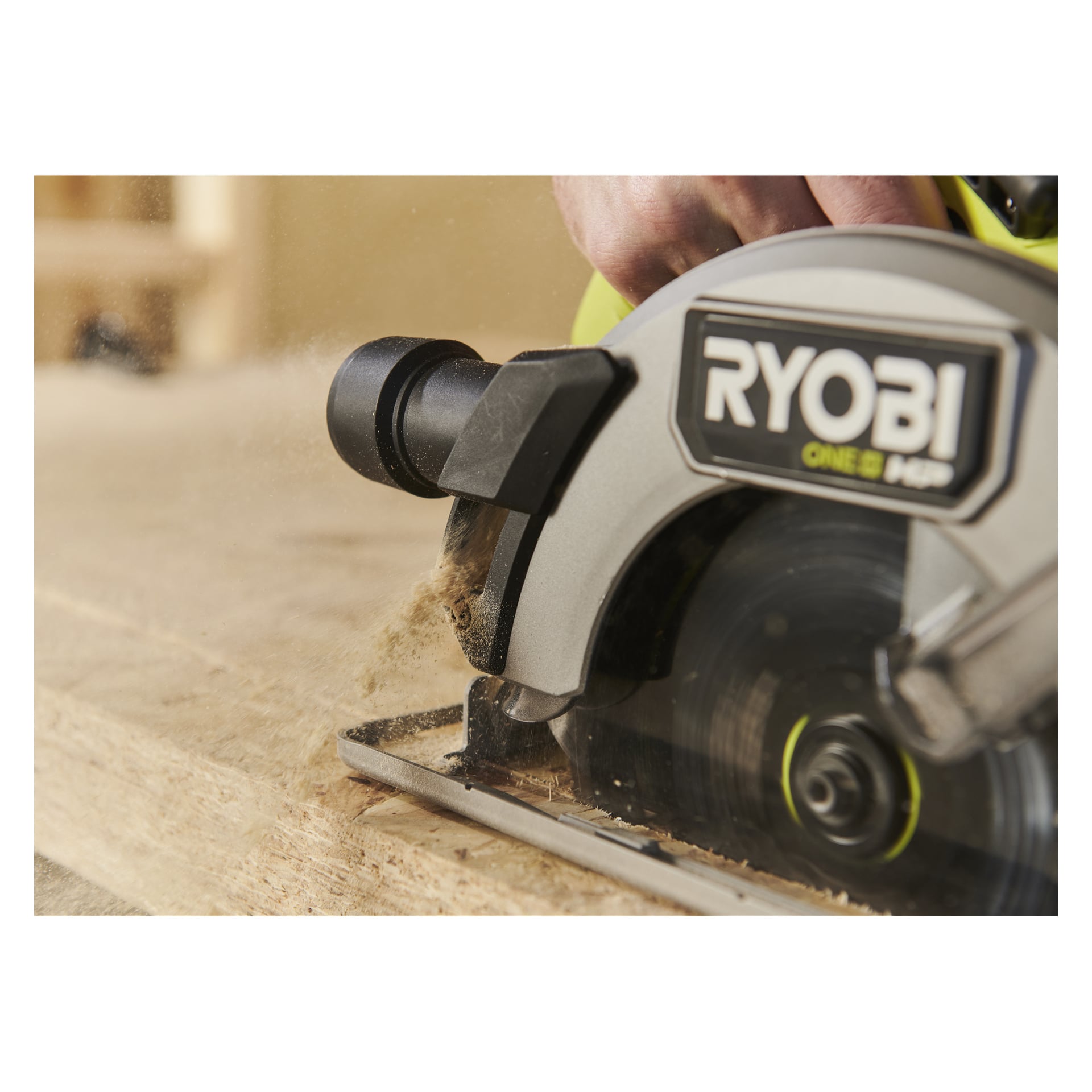 En person som betjener Ryobi One+ HP sirkelsag RCS18X1-0, og skjærer ved med sagflis som sprer seg mens bladet spinner.