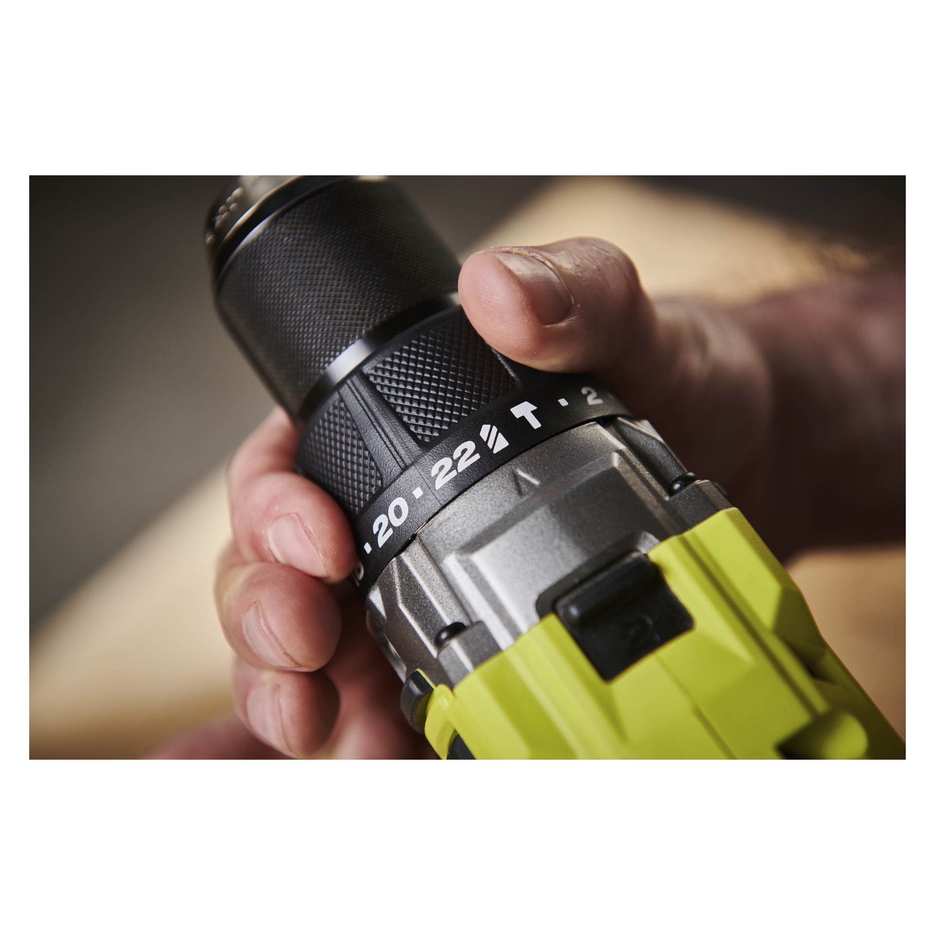 Hånden vrir dreiemomentjusteringsringen på en Ryobi One+ HP skrutrekker RPD18X1-0, med tall og T-symbol synlig.