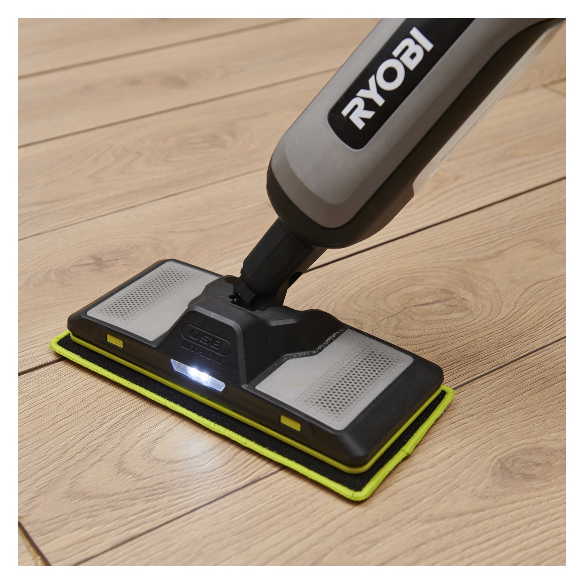 Ett Ryobi-rengöringsverktyg med rektangulärt mopphuvud och LED-lampa används för att rengöra ljusa trägolv.