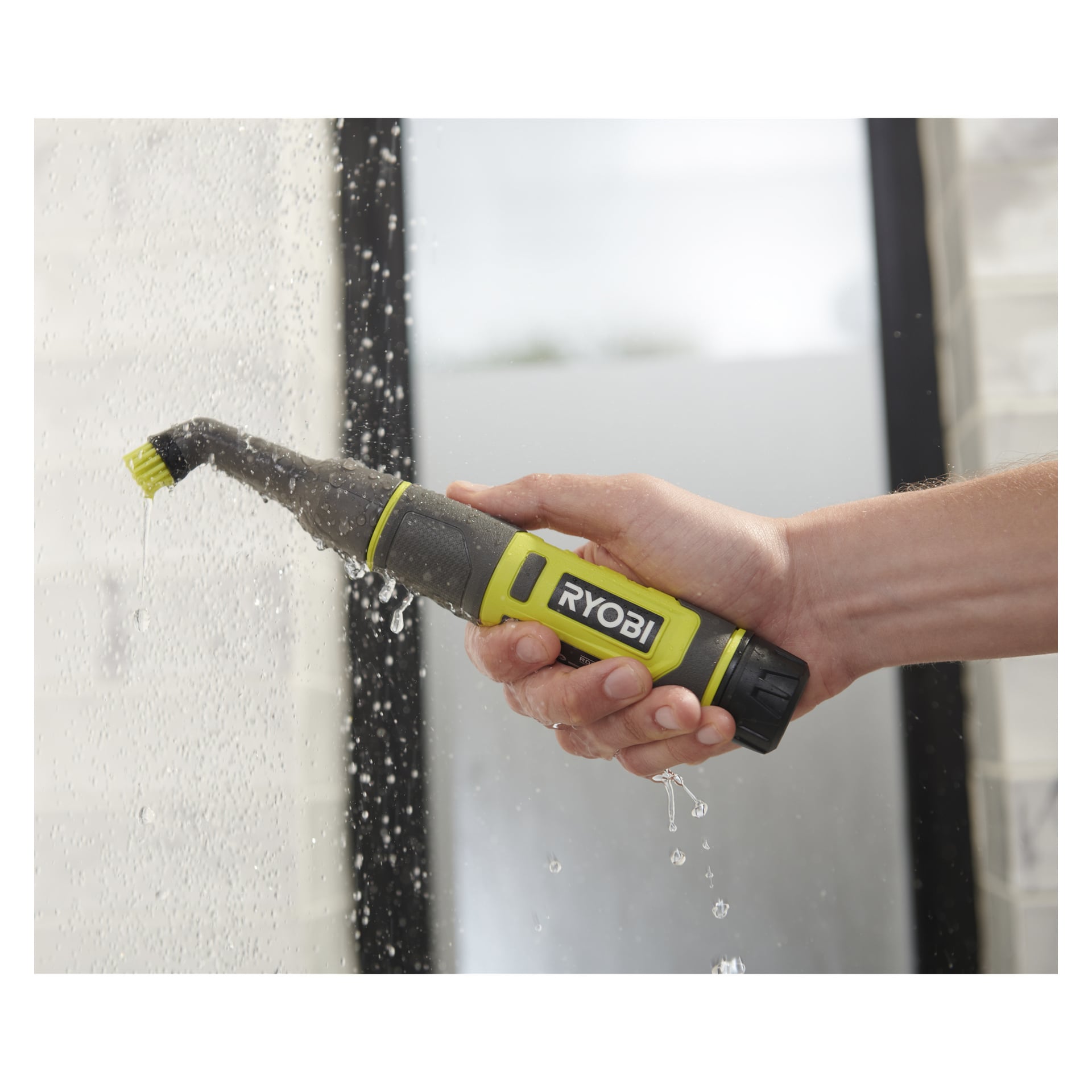 Man skrubbar en våt kaklad eller glasyta under rinnande vatten med Ryobi USB Lithium Battery detaljrengöringsborste RDS4-0.