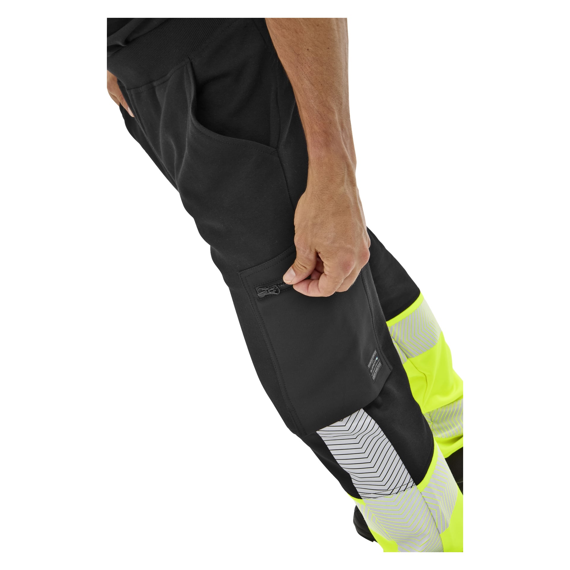 En hand stänger fickans dragkedja på Bluewear High Visibility Trousers Essex, som har gula och silverfärgade reflekterande ränder.