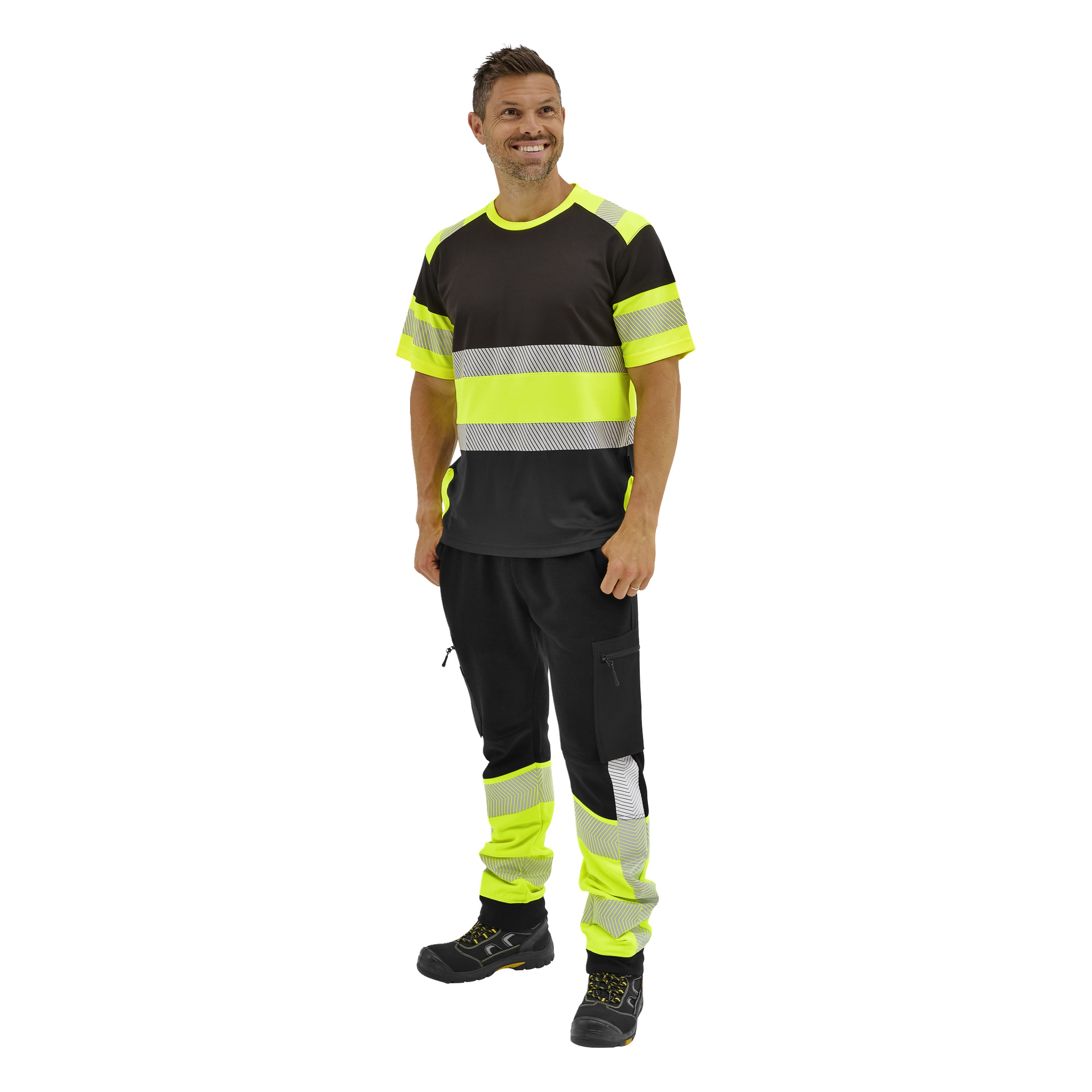 En leende man bär Bluewear högsynliga byxor Essex i svart och neongult med reflekterande ränder och svarta arbetsstövlar.