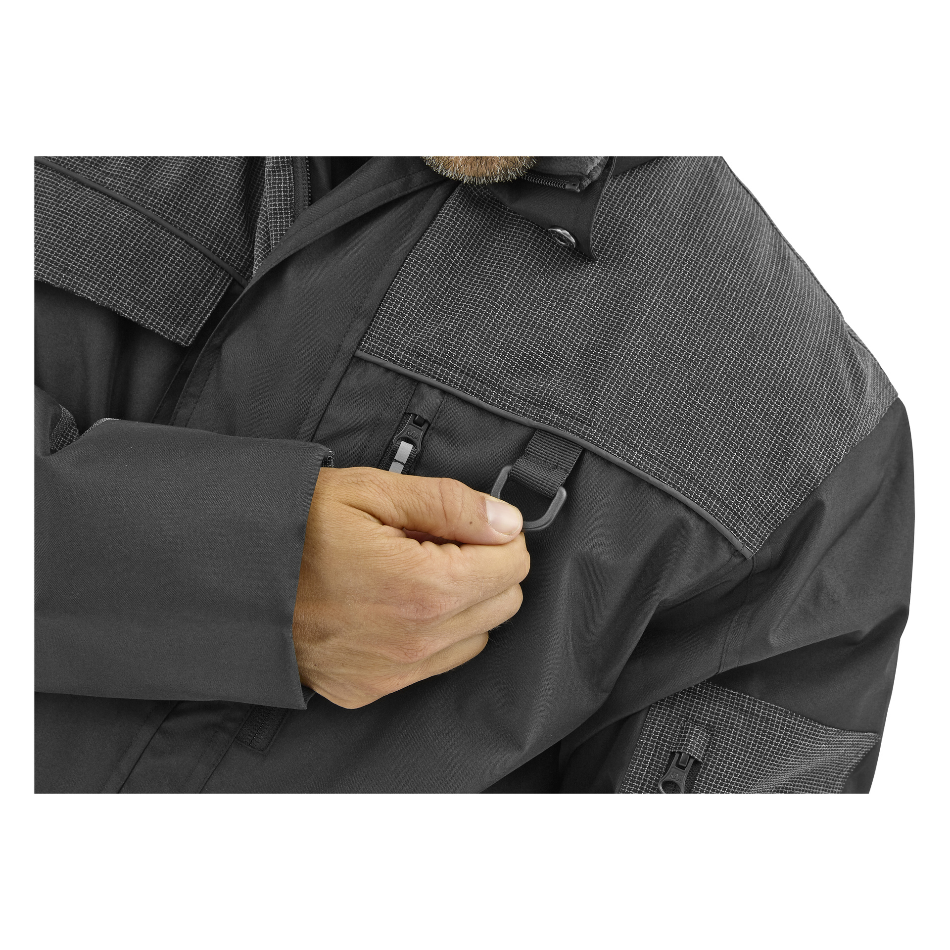 En person i en mörkgrå Bluewear Men's fodrad Johan-arbetsjacka håller en liten svart D-ring i den framre dragkedjasfickan; Endast bål och hand.