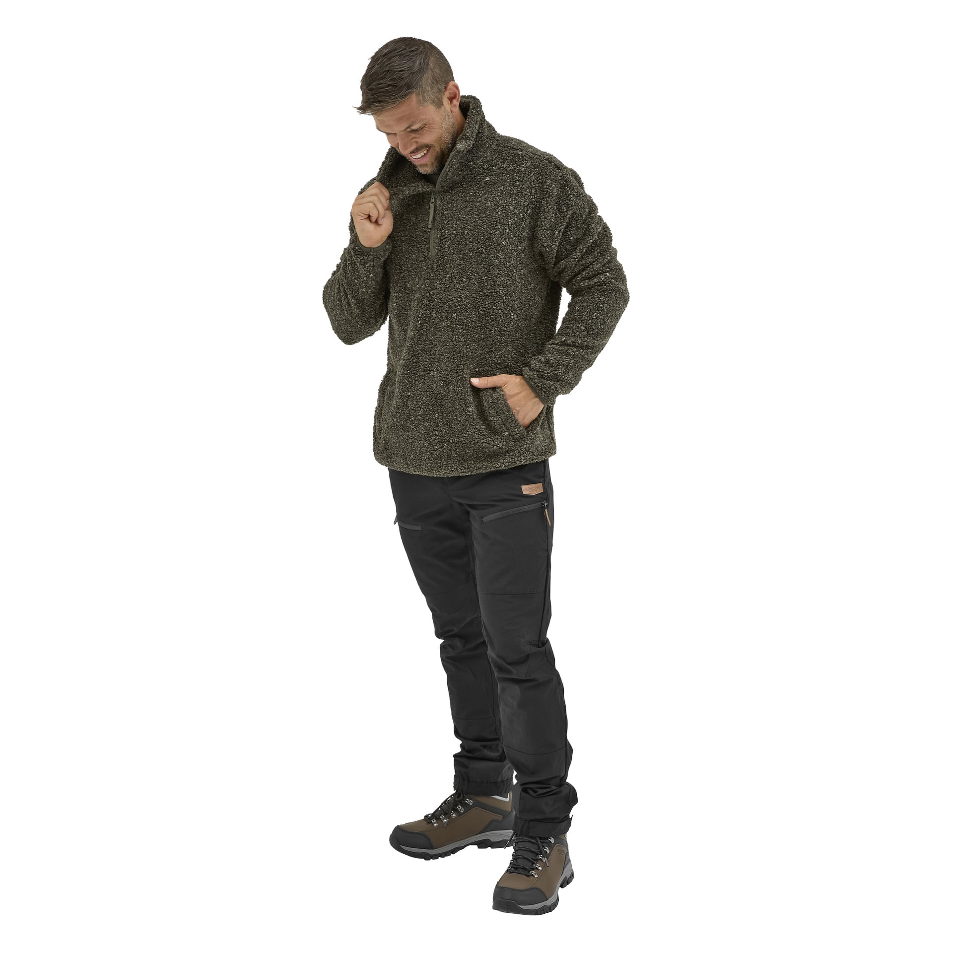 En man i en Kayoba Outdoor Men's pile-jacka, Hamra, svarta byxor och bruna vandringskängor står med ena handen i fickan och justerar sin krage.