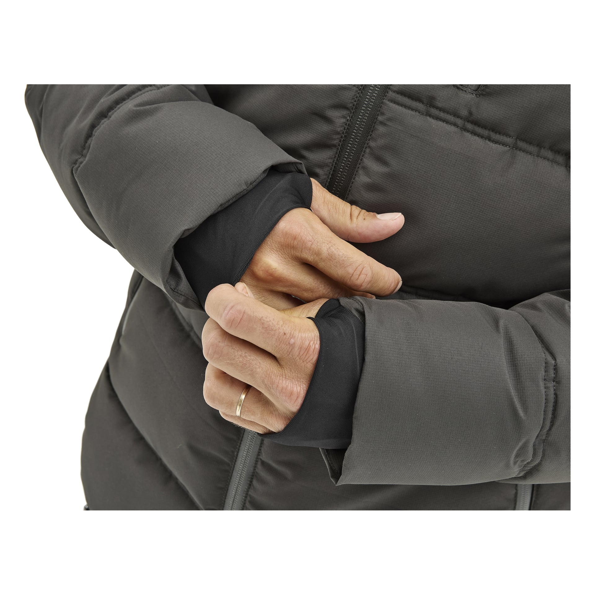Henkilö on yllään Kayoba Outdoor Men's talvitakki Sveg, jossa on mustat peukalonreiät hihat. Hänen kätensä ovat ristissä vartalossa, ja vasemmassa nimettömässä on yksinkertainen kultainen sormus. Näkyvissä on vain vartalo ja kädet; kasvot ja tausta eivät ole mukana.