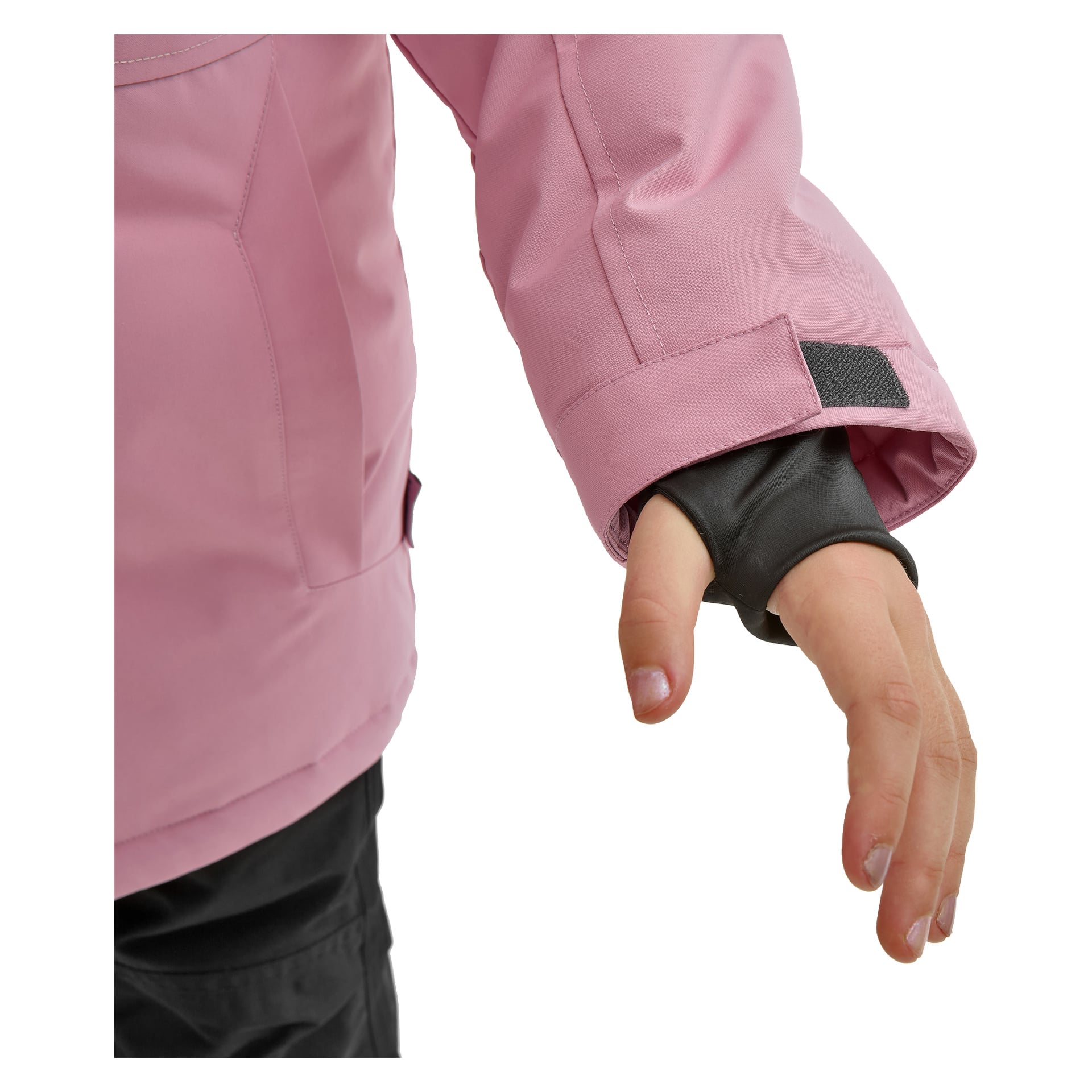 Ett barn i Kayoba Outdoor Children's vinterjacka Kläppen, rosa, med en svart innerärm som har ett tumhål och en kardborreband vid mudden. Endast den nedre delen av armen och handen syns, liksom en del av svarta byxor.
