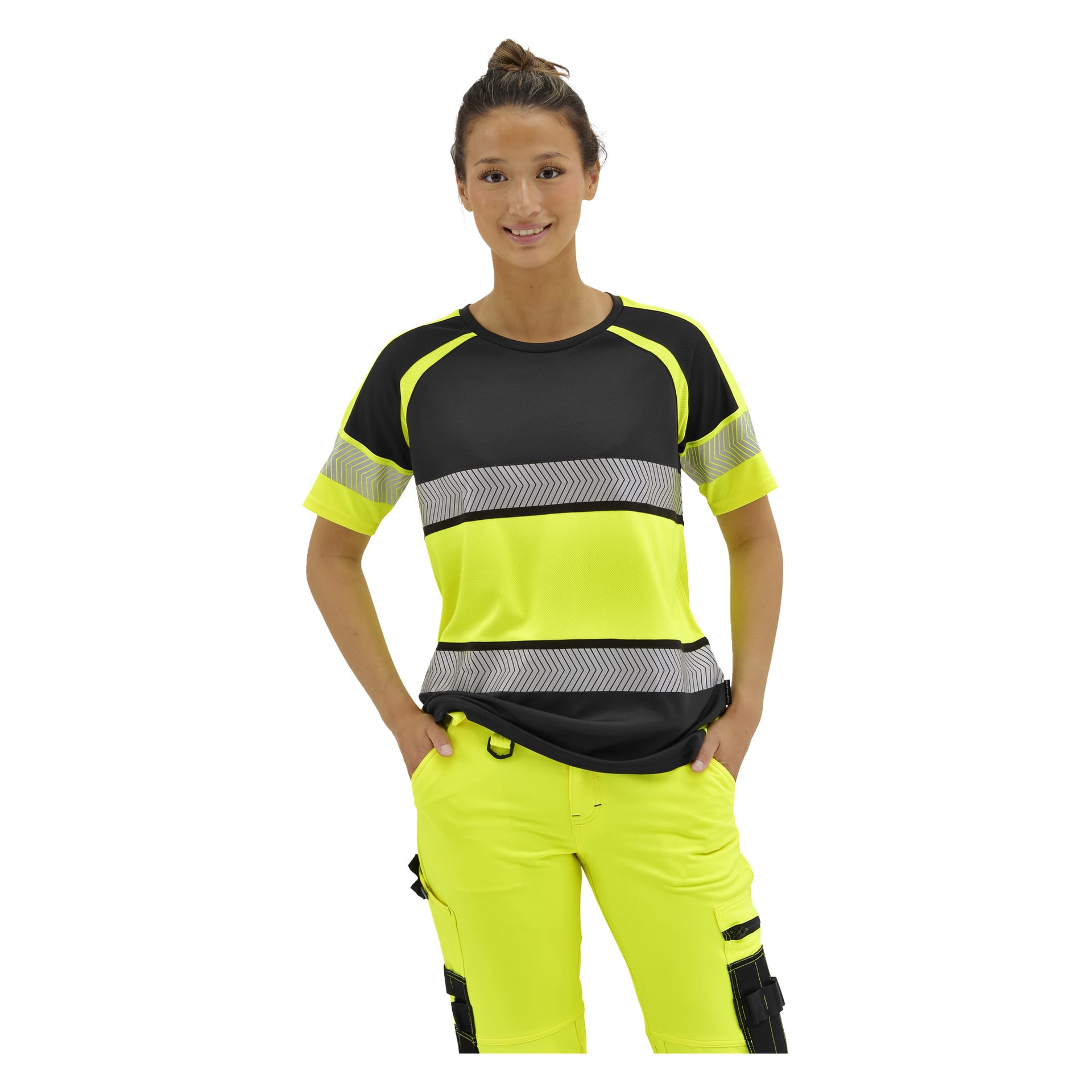 En leende person med händerna i fickorna bär en Bluewear Hi-Vis Lytton-tröja i svart och neongult, plus neongula arbetsbyxor.