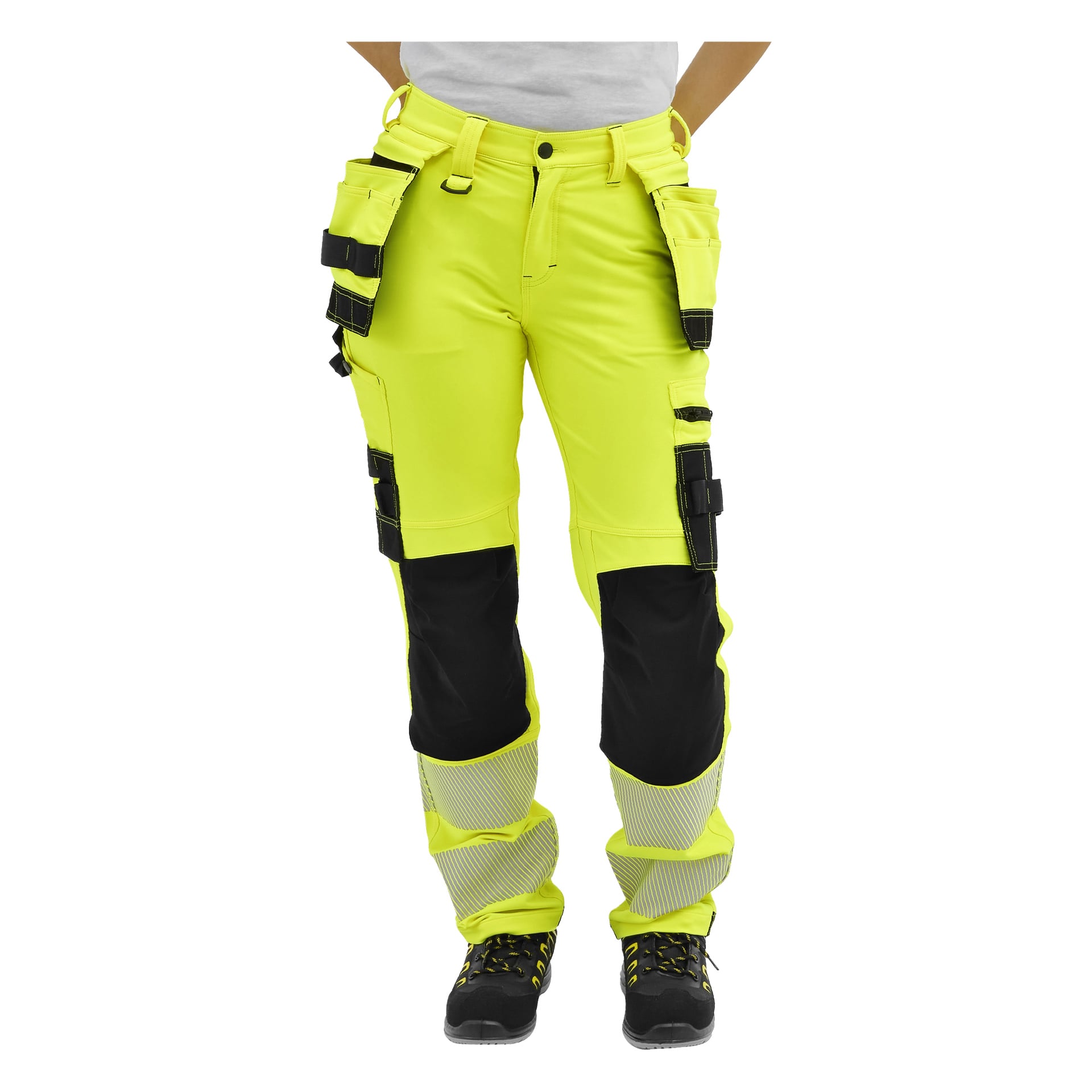 Personmodeller klargula Bluewear Pro hög-vis-byxor Stella, med svarta knälappar, reflekterande fotledsband och arbetsskor.