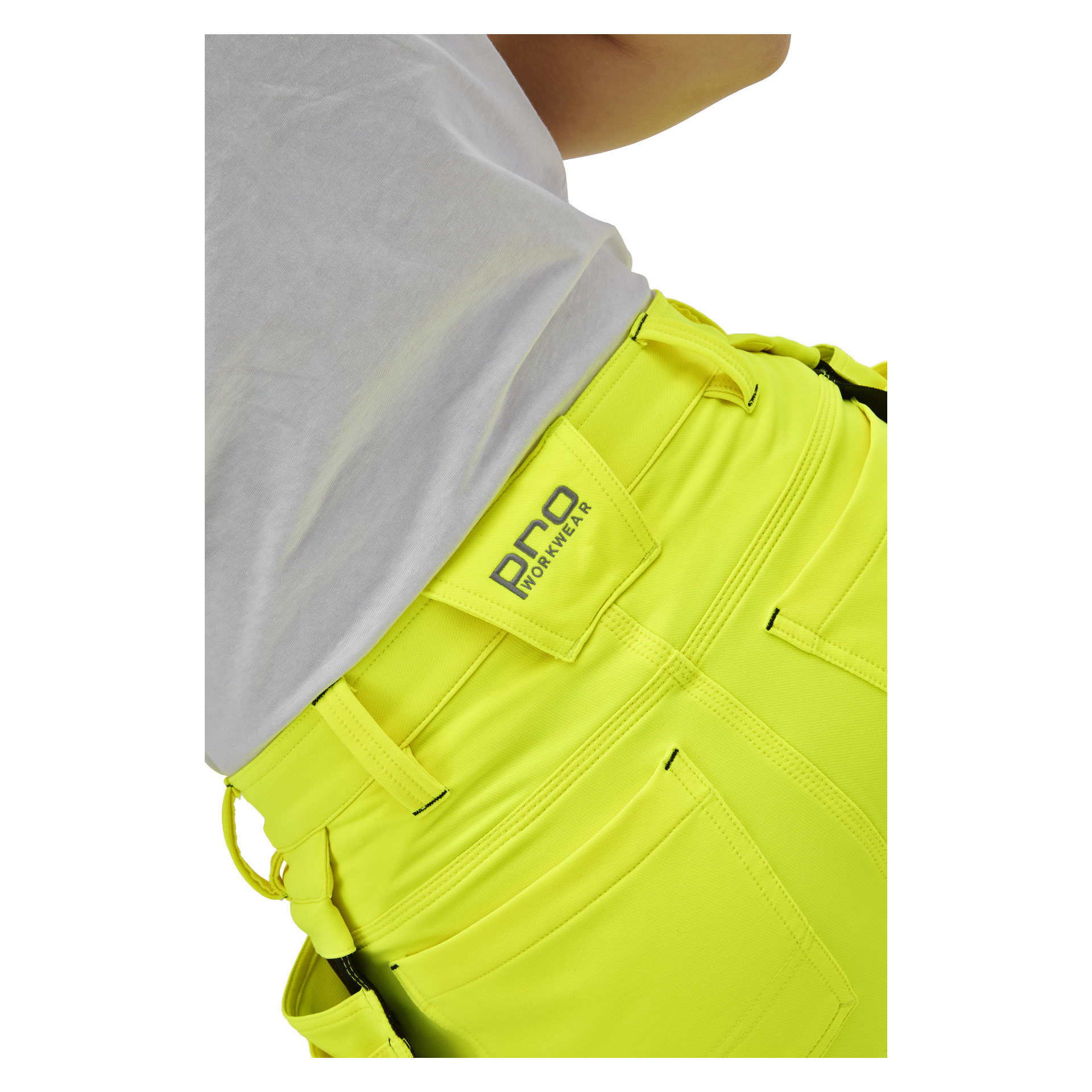 Närbild på en person i klargula Bluewear Pro Workwear Stella hög-vis-byxor med en lapp ovanför bakfickan och en vit skjorta.