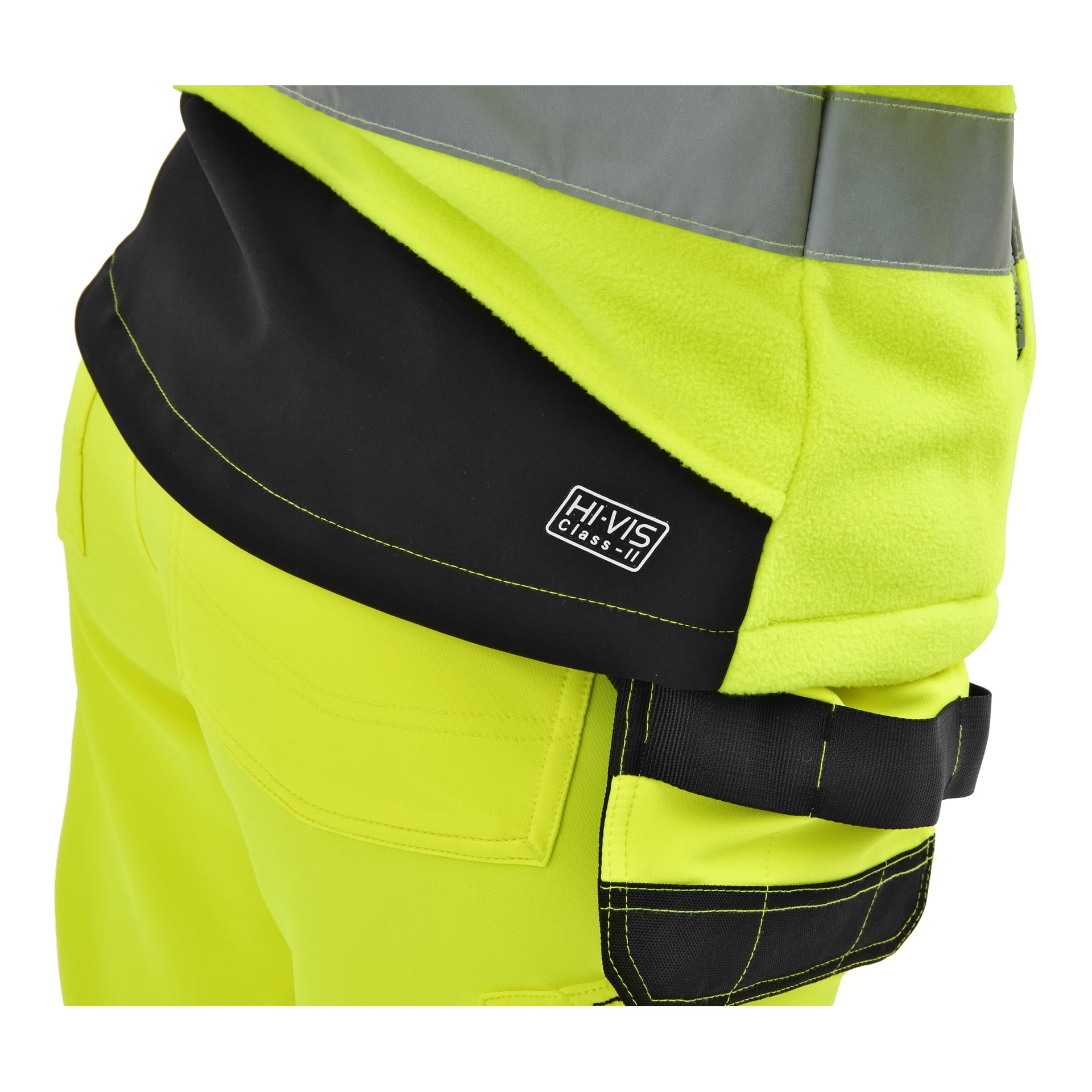 Närbild på en person i en Bluewear Ladies his-vis fleecejacka, gul med svarta detaljer, reflekterande remsa och Hi-Vis Class II-etikett. Svart verktygsögla på byxorna.