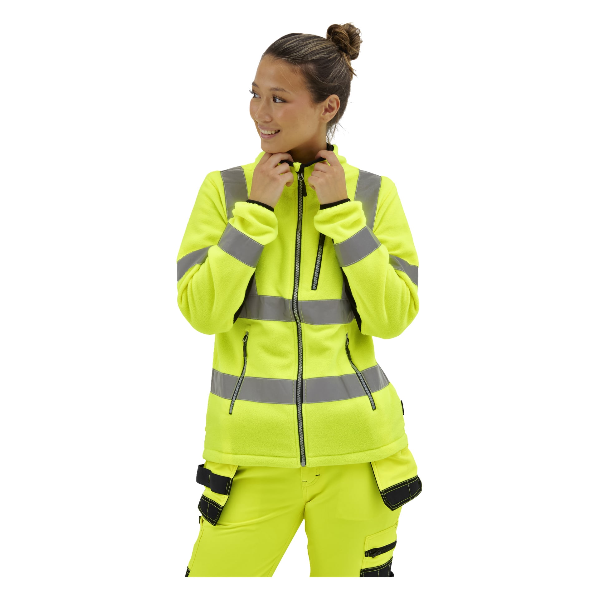Kvinna i en gul Bluewear Dames Hi-Vis fleecejacka med grå ränder håller i dragkedjan, ler och tittar åt sidan.