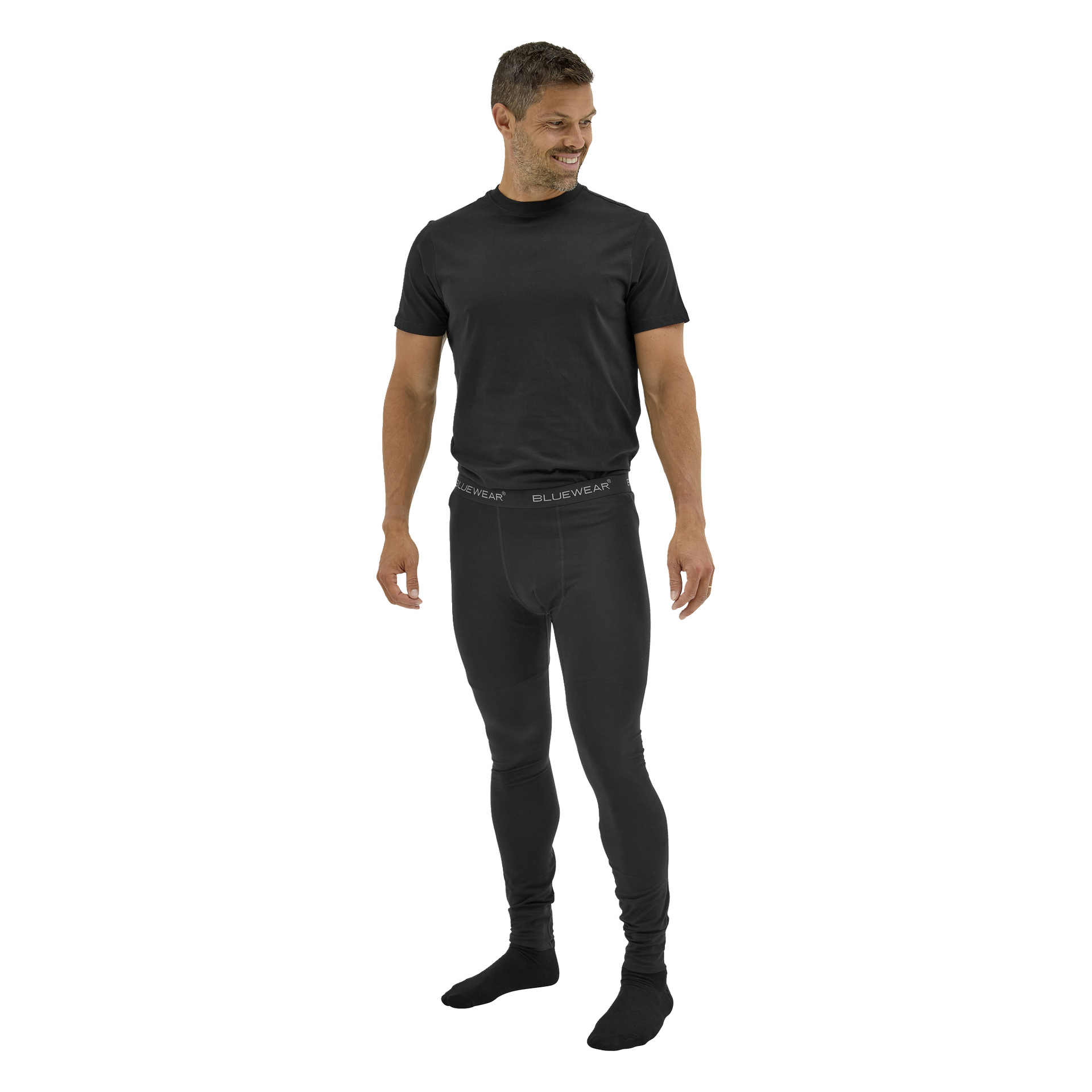 En leende barfota man bär en svart kortärmad T-shirt och Bluewear Long Johns Gnejs med loggan på midjebandet.