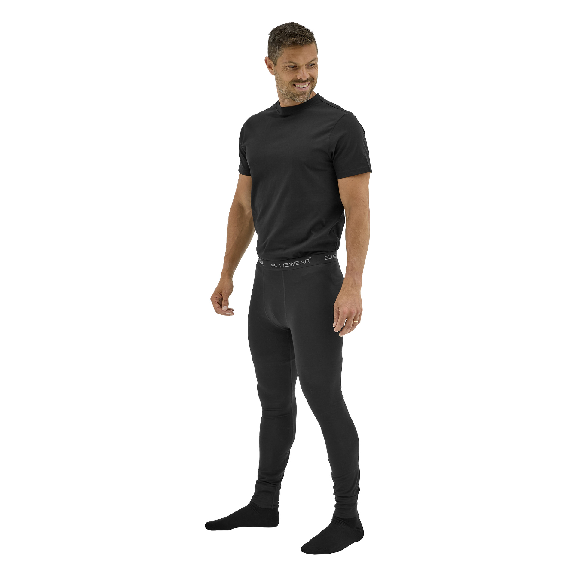 Leende person i svart kortärmad t-shirt, Bluewear Long Johns Gnejs med märkeslinning och svarta strumpor.