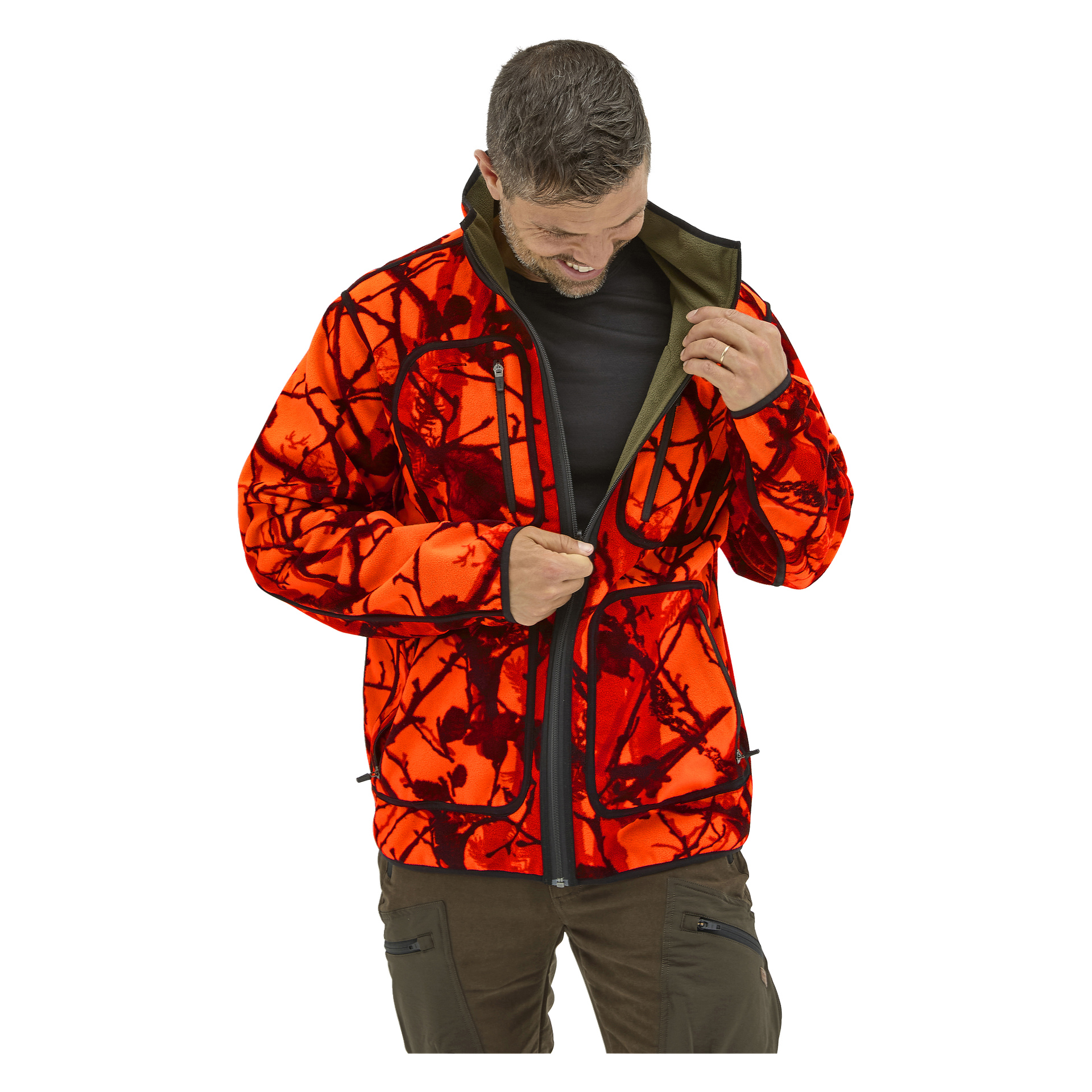 Den leende mannen drar igen en orange Kayoba Outdoor fleecejacka med röd och svart kamouflage, iklädd mörka byxor och svart skjorta.
