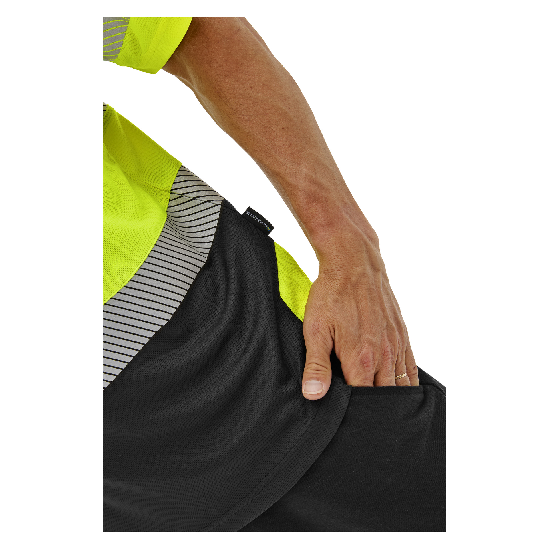 En hand drar i midjebandet på svarta sportshorts. Personen bär en Bluewear kortärmad Hi-Vis Laval-tröja med en liten lapp nära fållen.