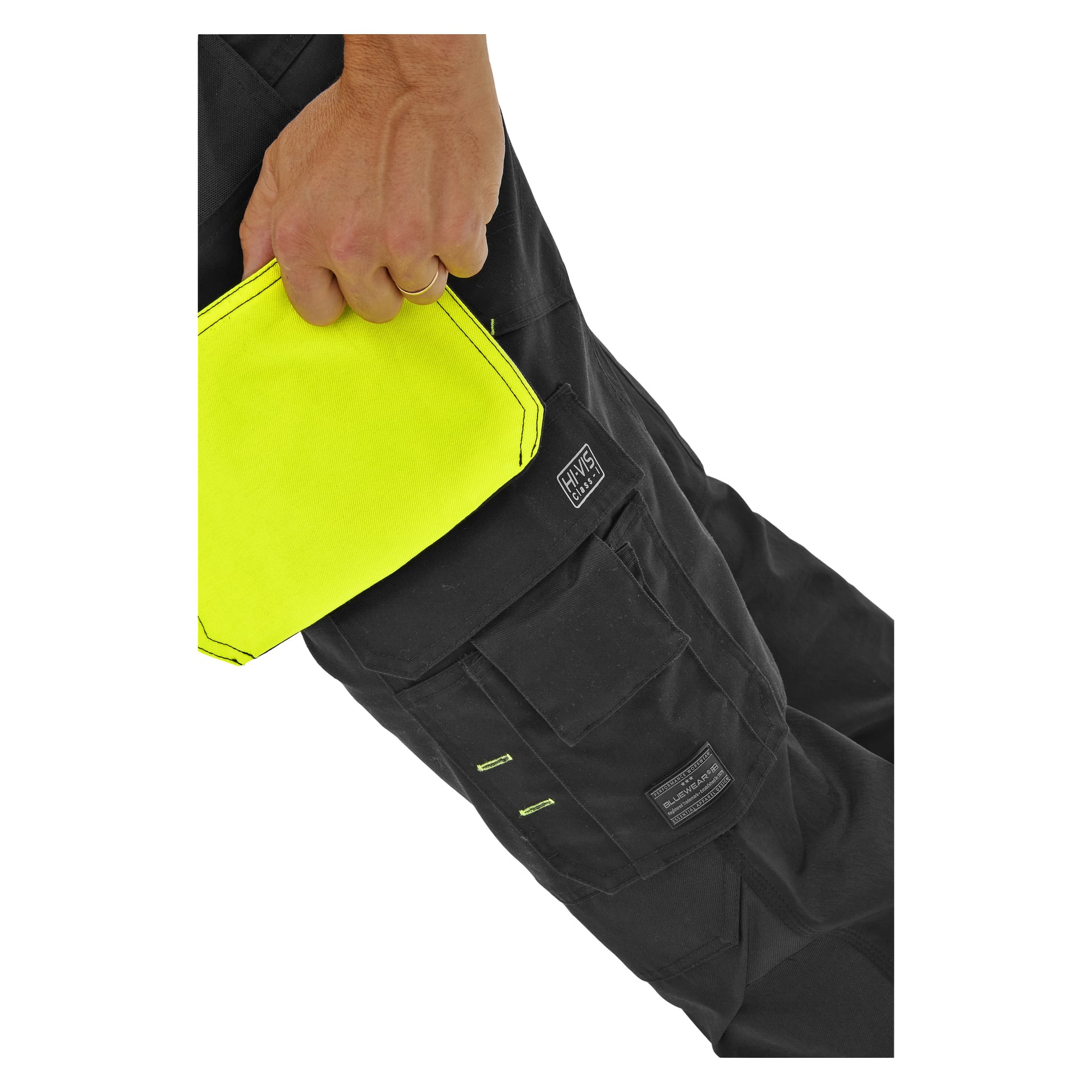Någon i Bluewear High Visibility Trousers Rex med synliga sömmar och lappar håller ett klargult tyg i fickan.