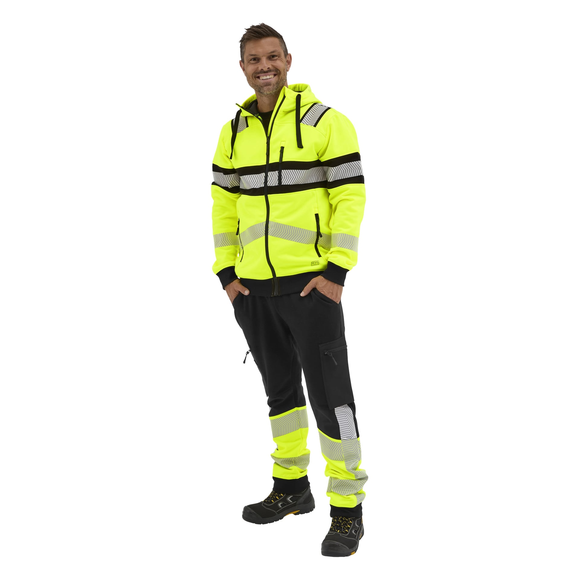Ein lächelnder Mann trägt einen neongelben Bluewear Hi-Vis-Kapuzenpullover mit schwarzen Details und reflektierenden Streifen, passende Hosen und schwarze Stiefel.