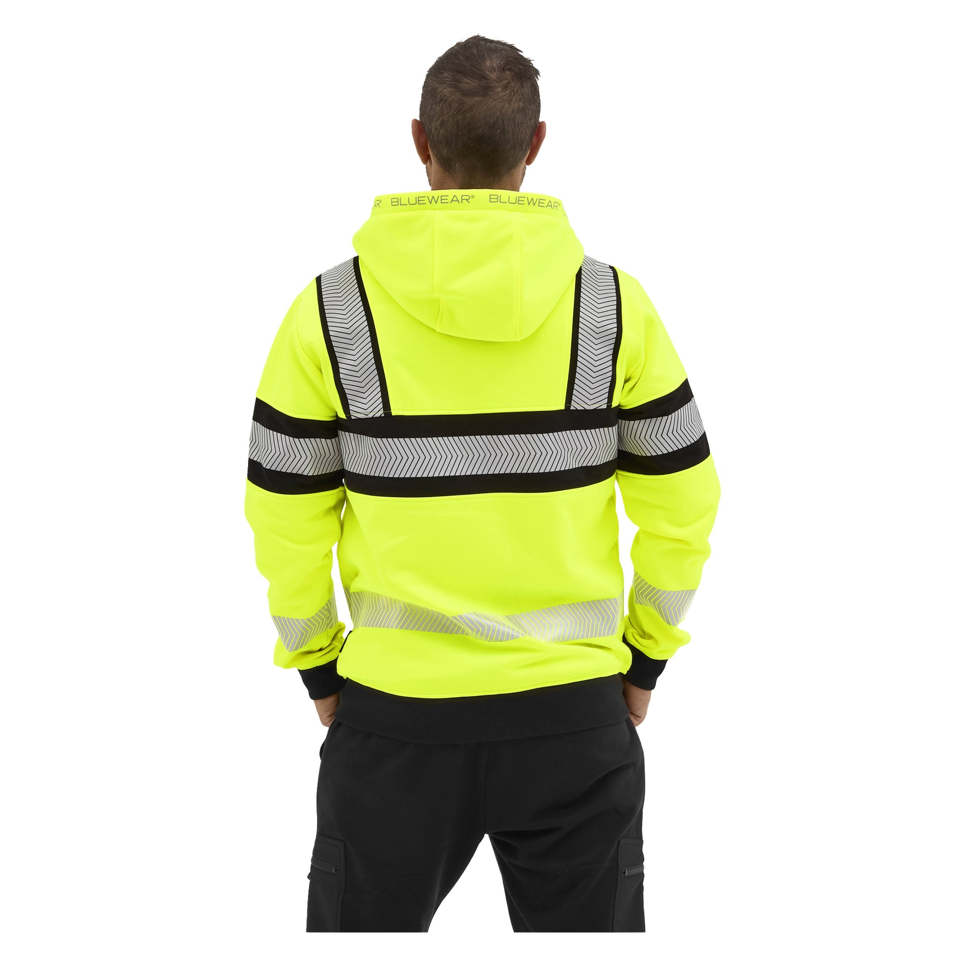 Sett bakifrån bär personen en gul Bluewear högtidshuva med ränder och "BLUEWEAR" på kragen, plus svarta byxor.