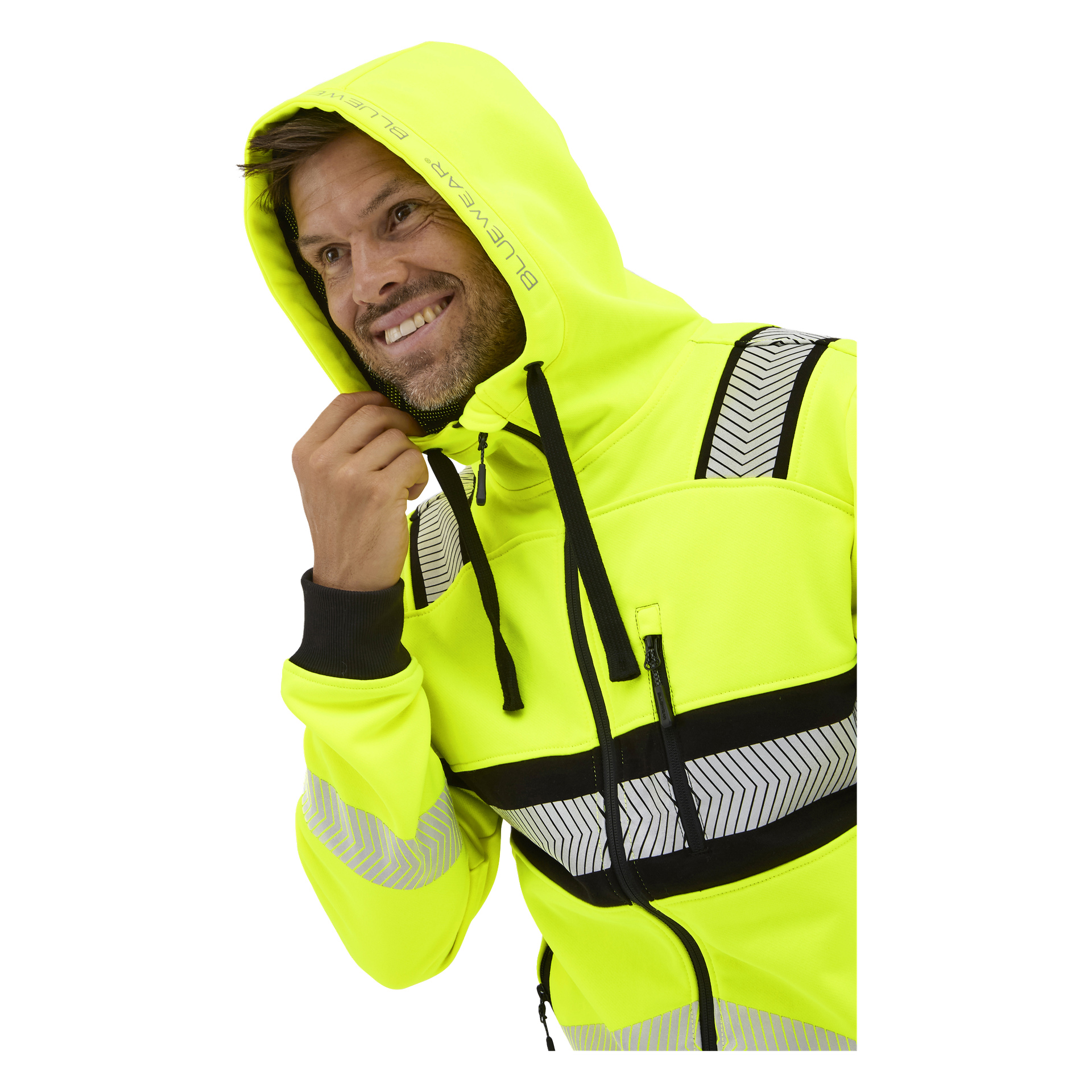En leende person i en ljusgul Bluewear Hi-vis Chambley-hoodie med reflekterande ränder och svarta dragsnören håller huvan.