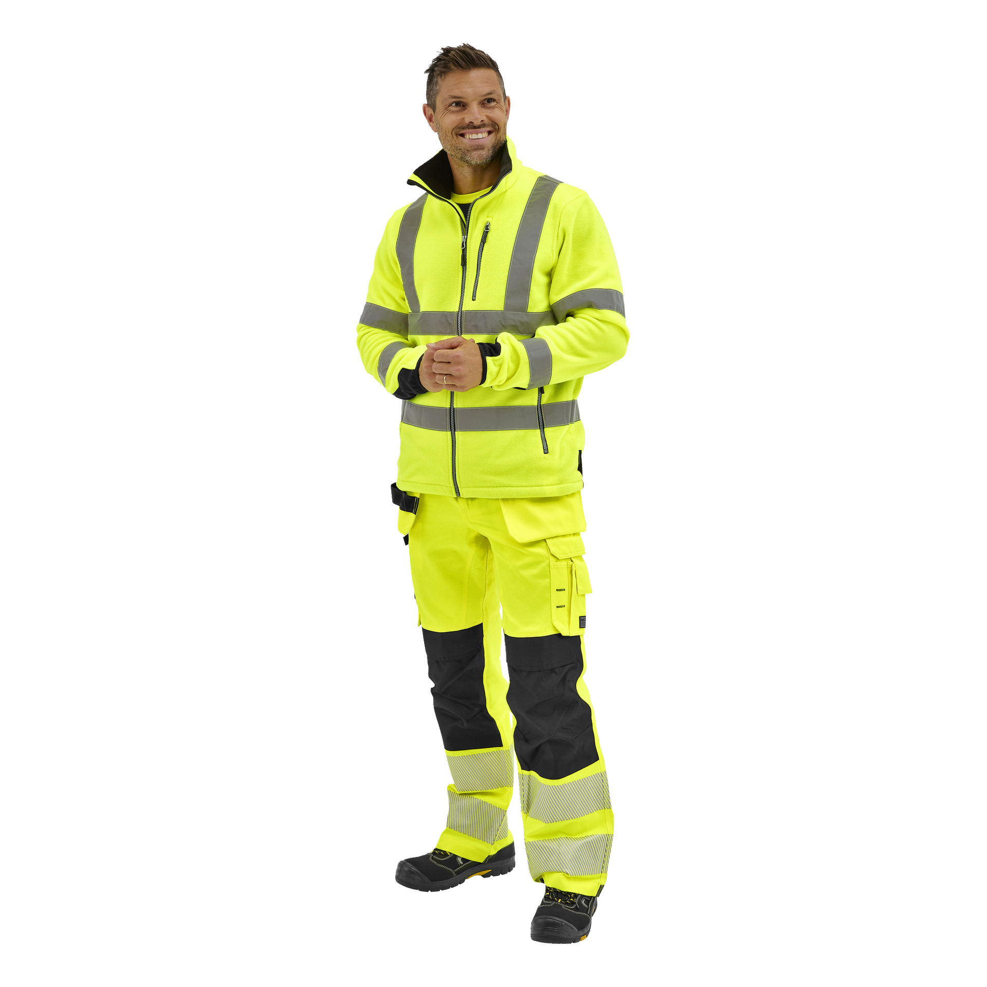 En person bär Bluewear Hi-Vis fleecejacka Chase och matchande byxor med reflekterande ränder, svarta stövlar och en svart skjorta, vänd något åt höger och leende.