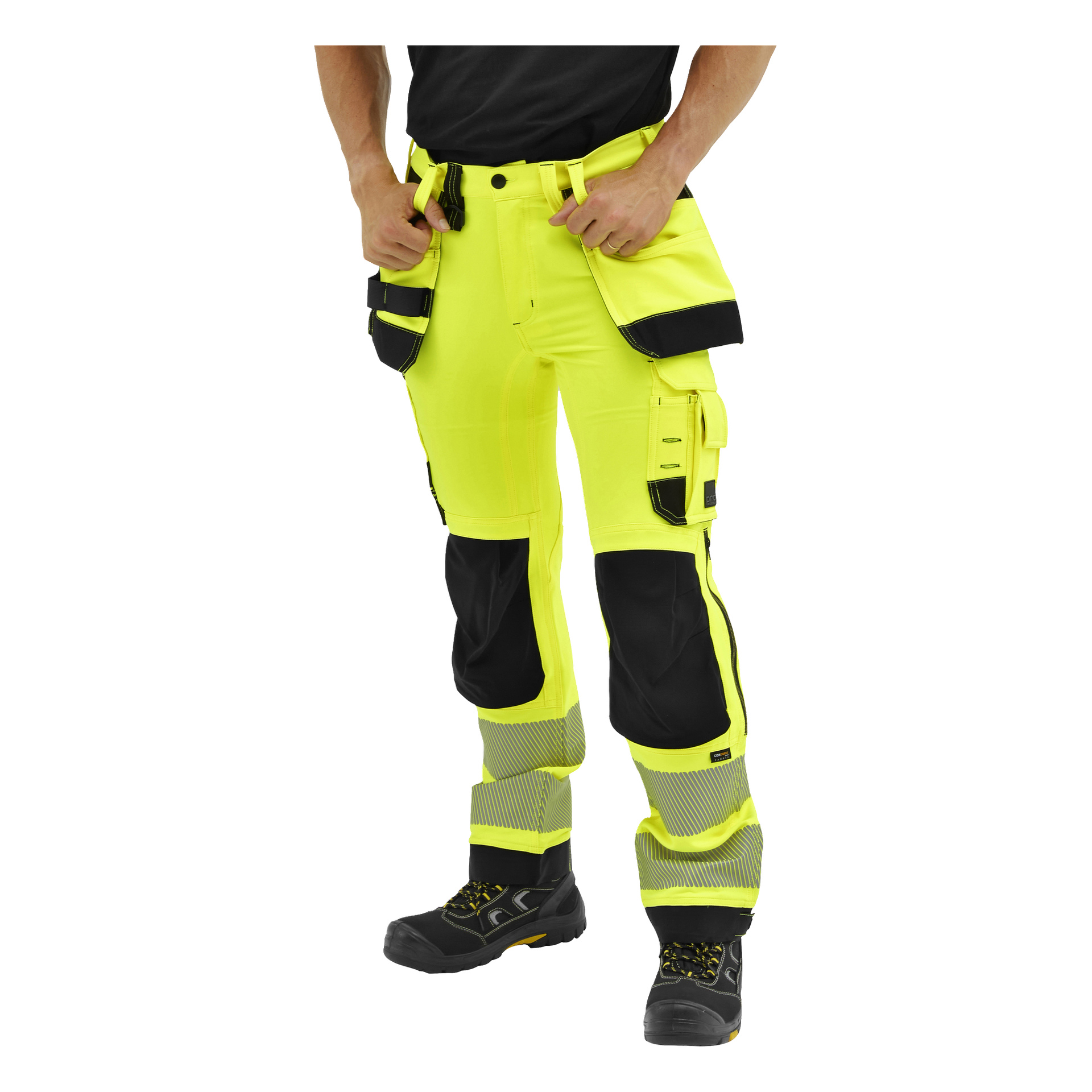 Någon justerar fickorna på Bluewear Pros gula arbetsbyxor med svarta knän, reflekterande band och många fickor, och bär matchande stövlar.