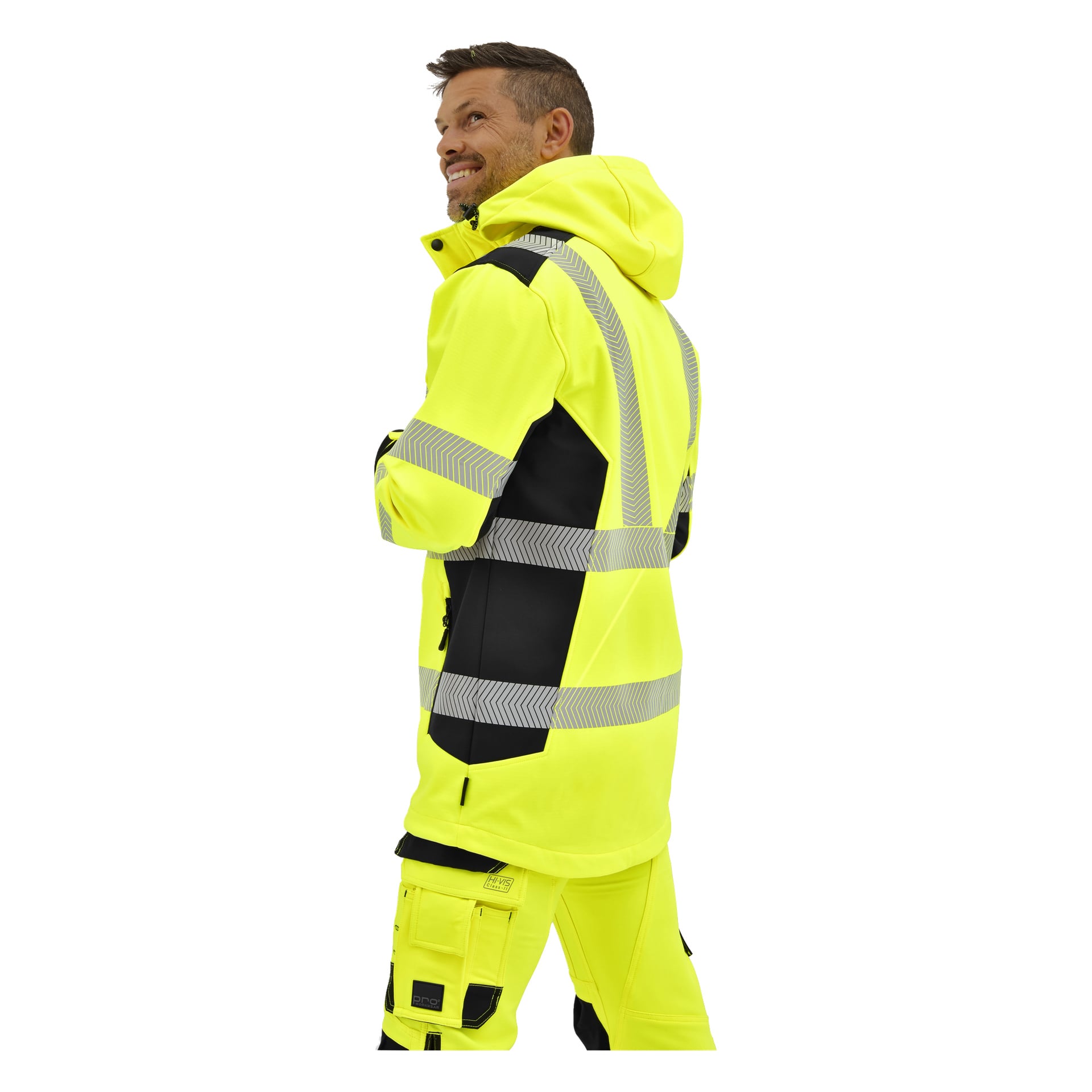 En person i en klargul Bluewear Hi-Vis Kingston-jacka med reflekterande ränder står på sidan och tittar upp med ett svagt leende.