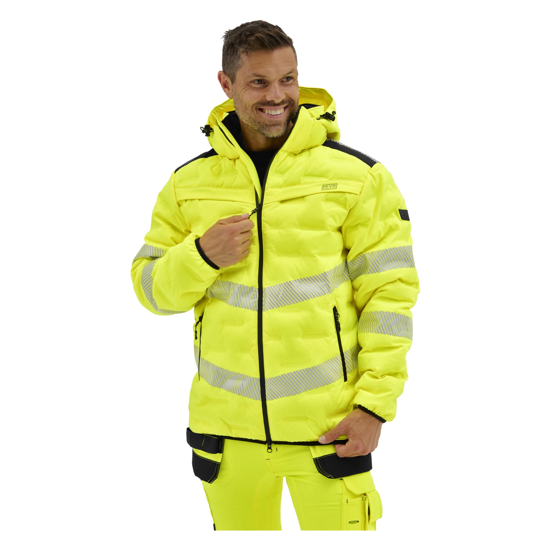 Leende man i en zip-försedd Bluewear Pro Workwear-jacka med reflekterande ränder, svarta detaljer och matchande byxor.