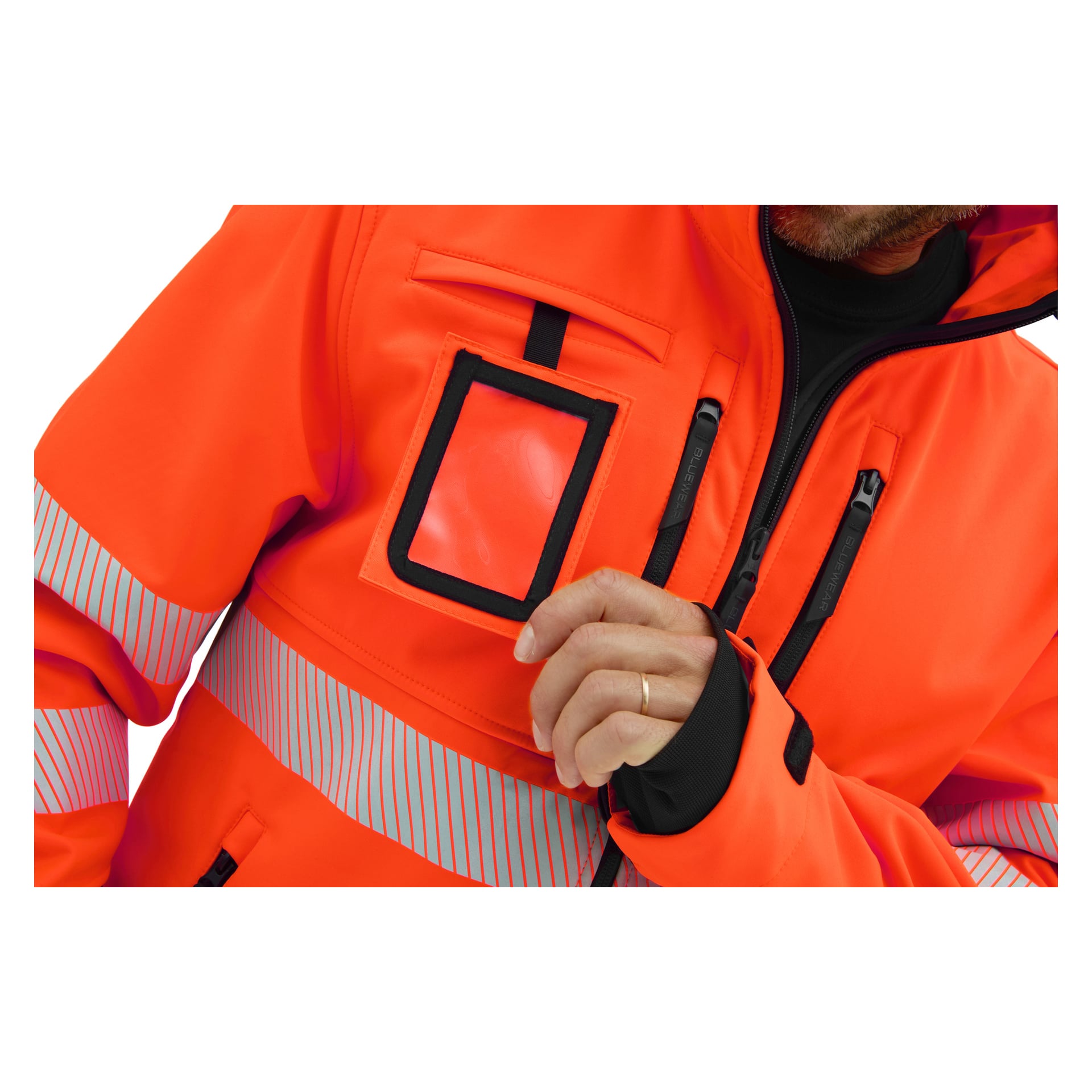 Någon i en Bluewear Hi-Vis Toronto softshelljacka med reflekterande ränder visar en öppen genomskinlig plast-ID-hållare på bröstet.
