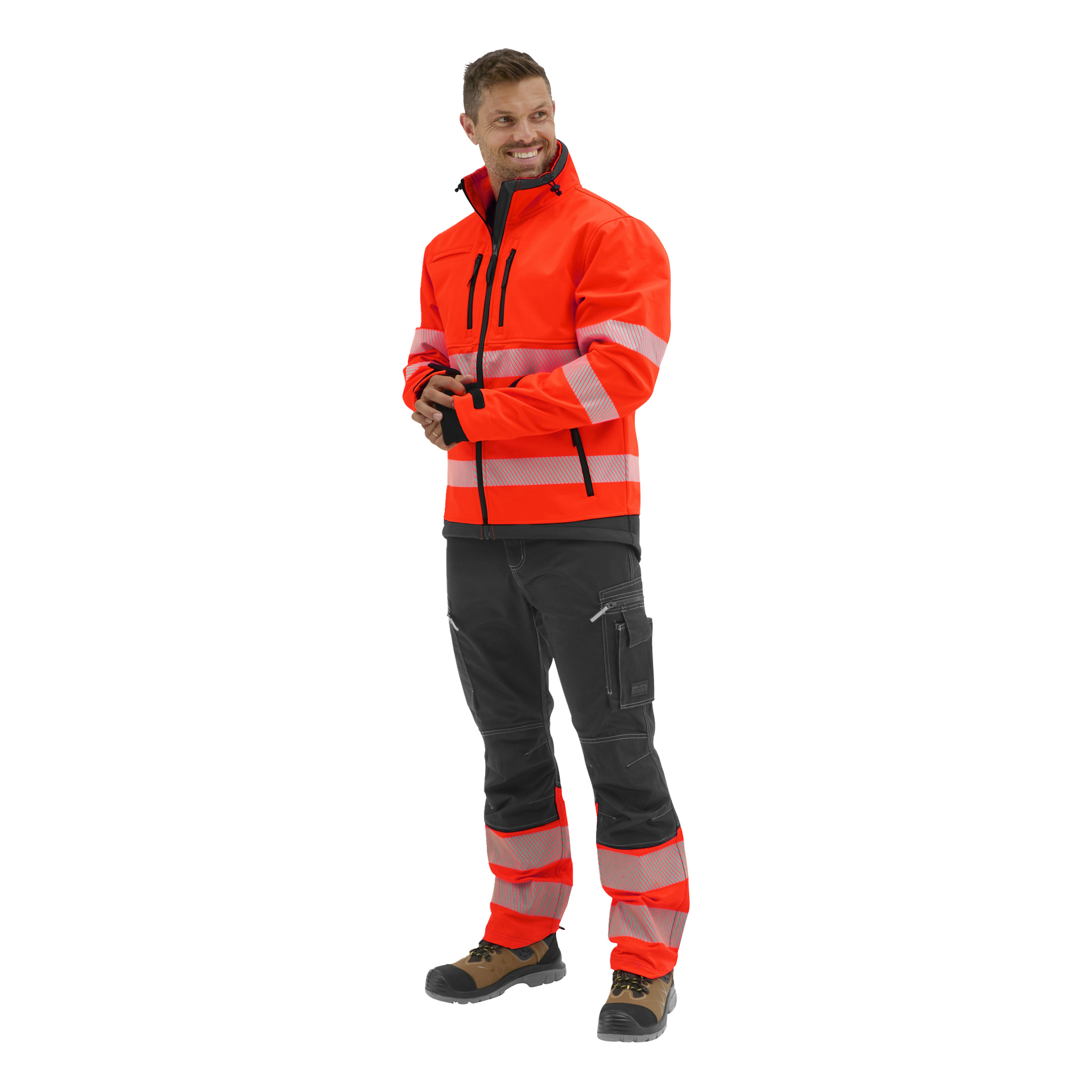 Leende person som tittar åt vänster i en orange Bluewear Hi-Vis Toronto softshelljacka med reflekterande ränder, matchande byxor, svart skjorta och arbetskängor.