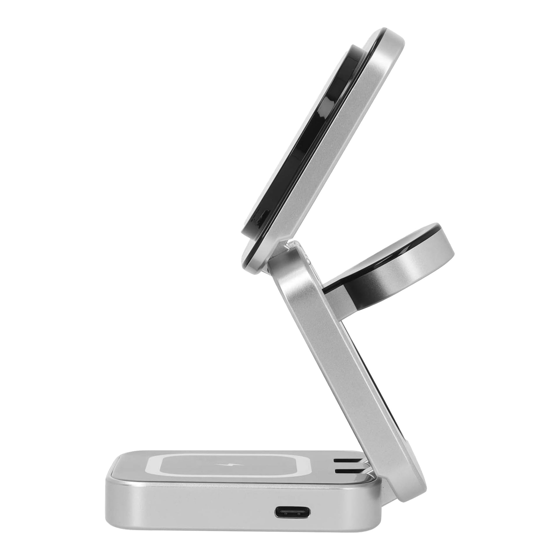 Den sølvfargede, sammenleggbare trådløse ladestasjonen vises på sidebildet. Enheten har to sirkulære ladeputer, den ene oppå den andre, forbundet med et hengsel. En USB-C-port er synlig nederst.
