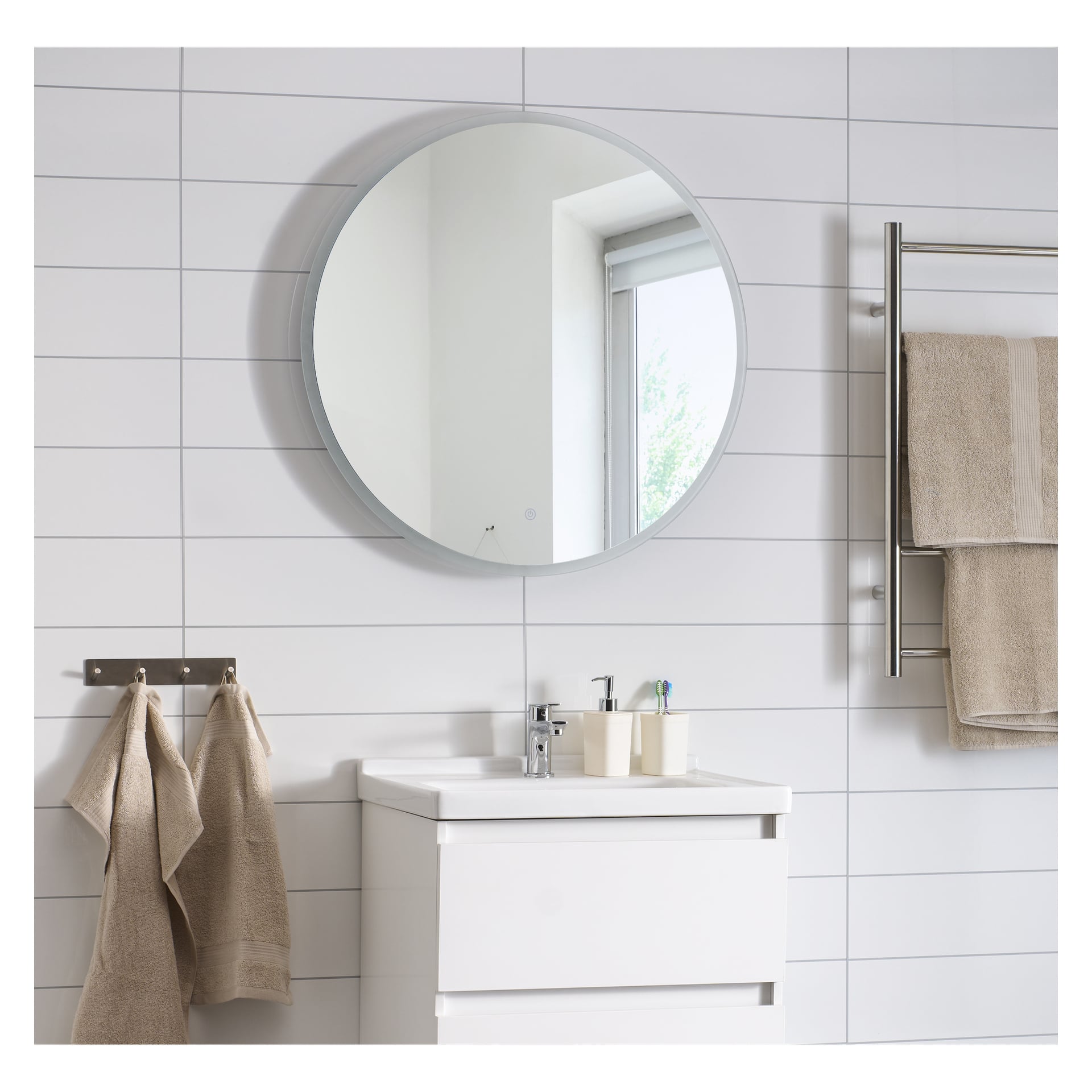 Badet med hvite fliser, EKVIP LED-speil over hvitt vaskskap, beige håndklær på stativ og kroker, vindu reflektert i speilet.