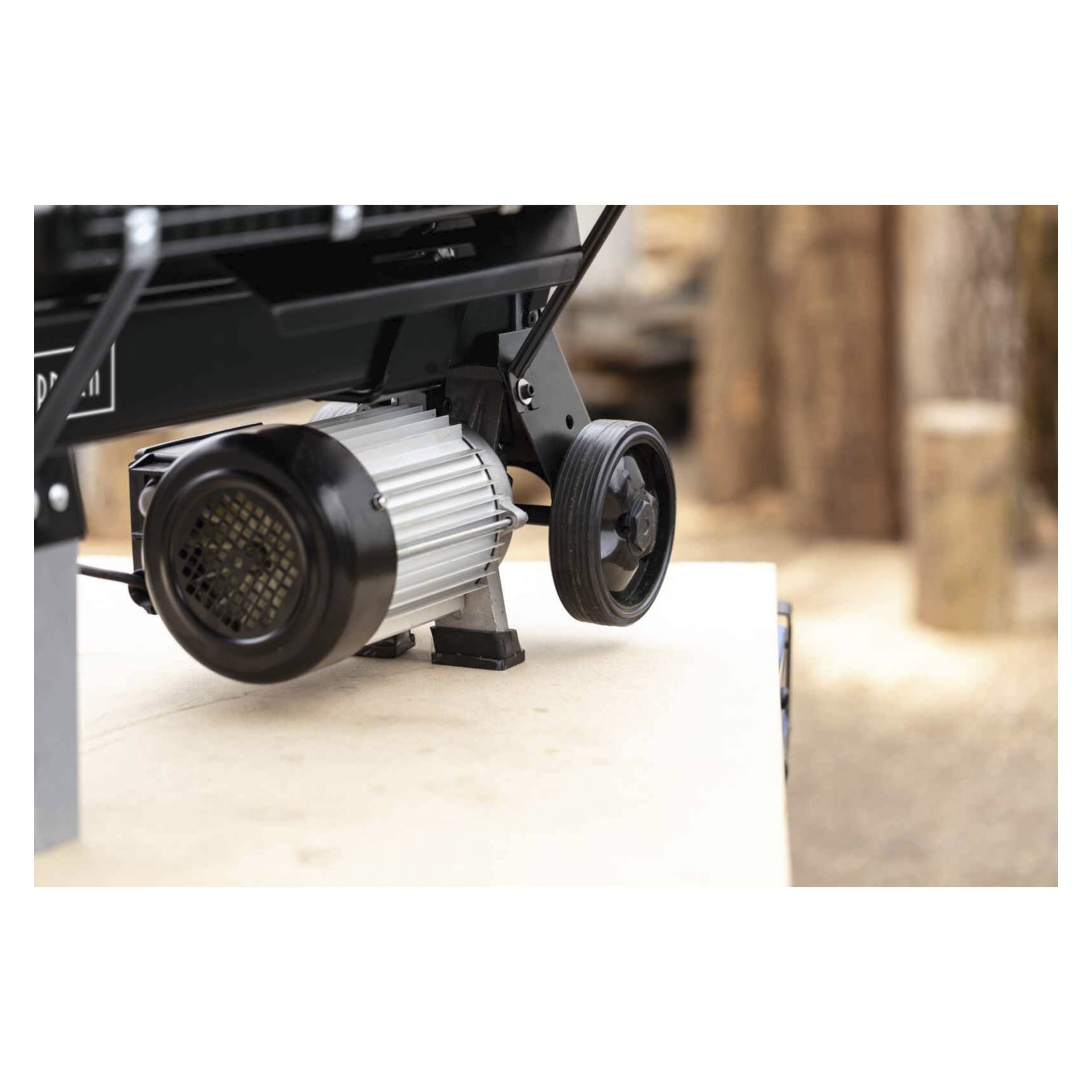 Närbild av Scheppach Log splitter BLS7L Black Edition framhäver motorn och ett svart hjul, bakgrunden mjukt suddig.