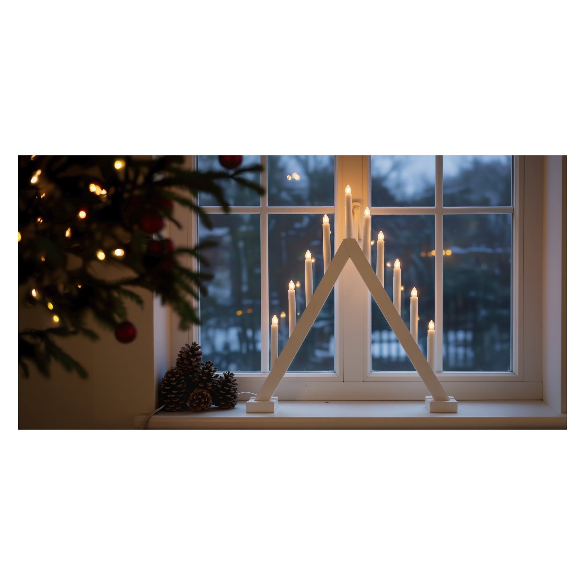 Ein großer EKVIP LED-Adventskerzenhalter mit neun leuchtenden Lichtern auf einer Fensterbank, mit Kiefernzapfen und immergrünen Bäumen, steht draußen bei Einbruch der Dämmerung.
