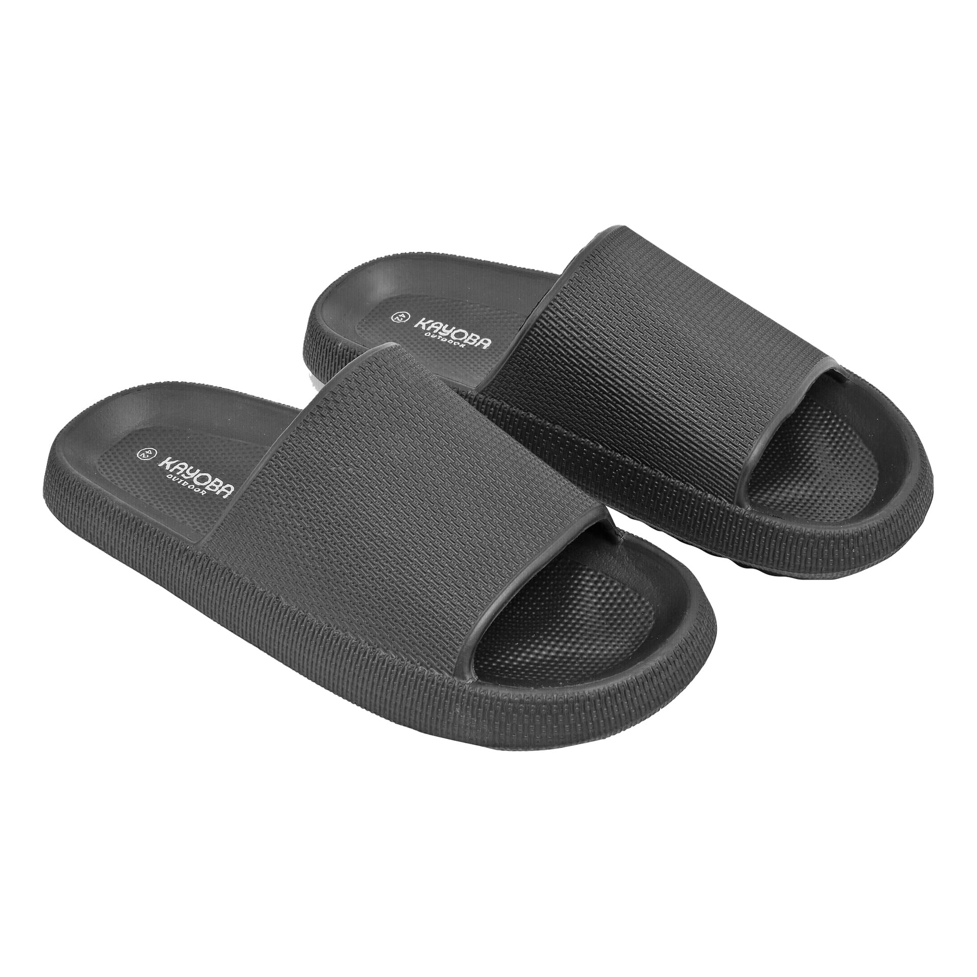 Schwarze Slide-Sandalen mit strukturierter Sohle und breiten Riemen auf der Oberseite, die das weiße Kayoba-Branding auf dem Fußbett zeigen.