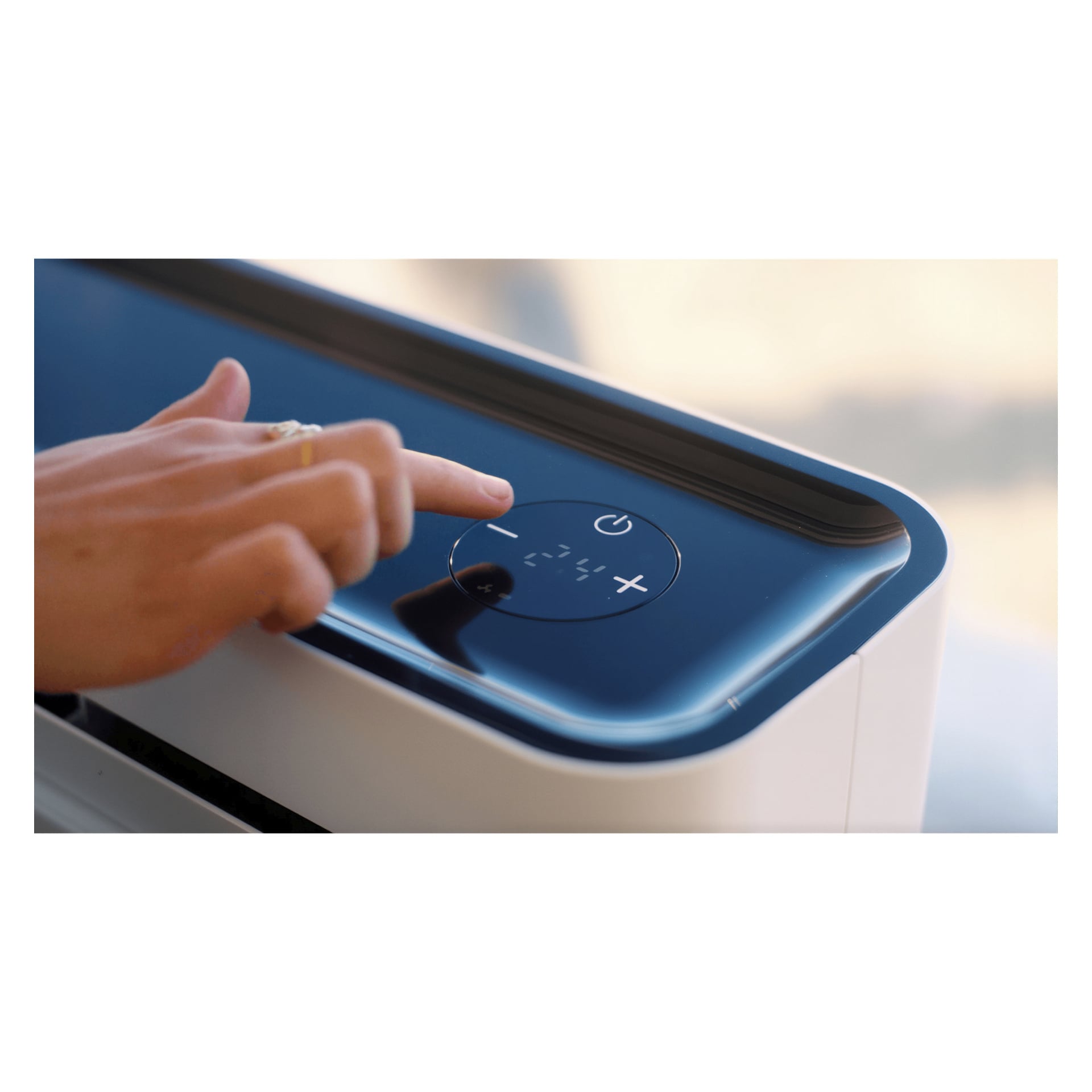 Tryck med handen på strömknappen på en elegant enhet med en digital skärm och pekkontroller för att justera inställningarna.
